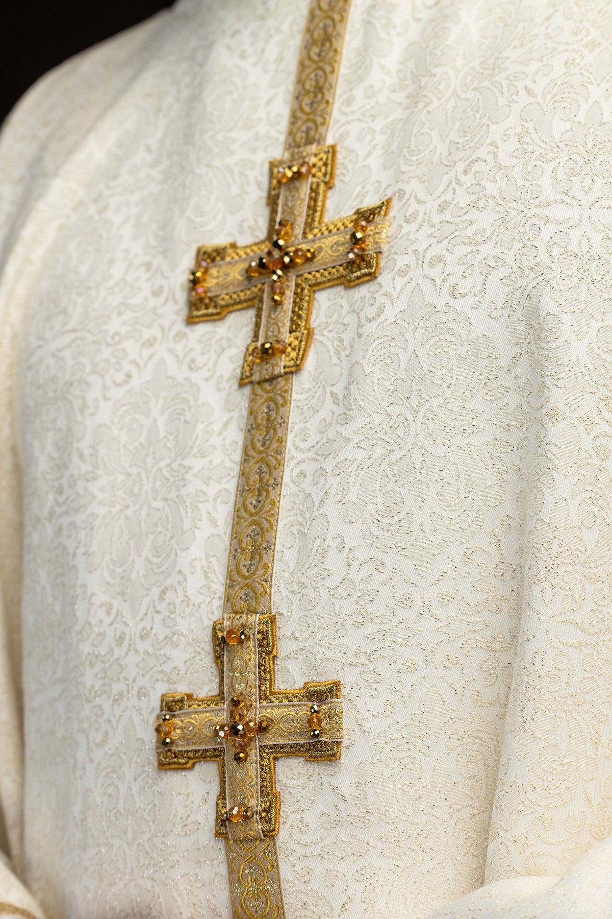 Chasuble close-up showing two jeweled crosses on the gold central band