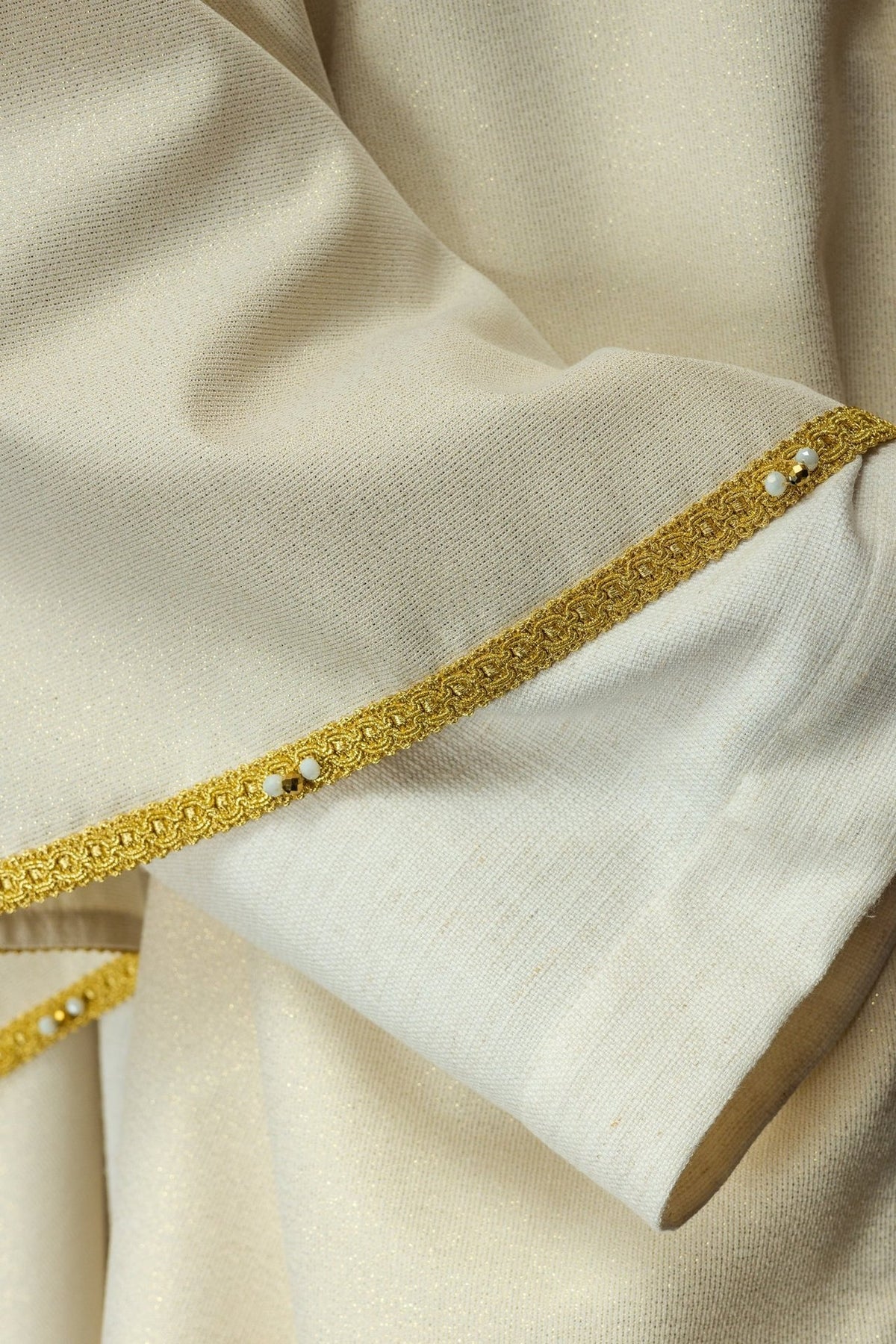 White chasuble collar close-up with gold embroidery and natural stone embellishments