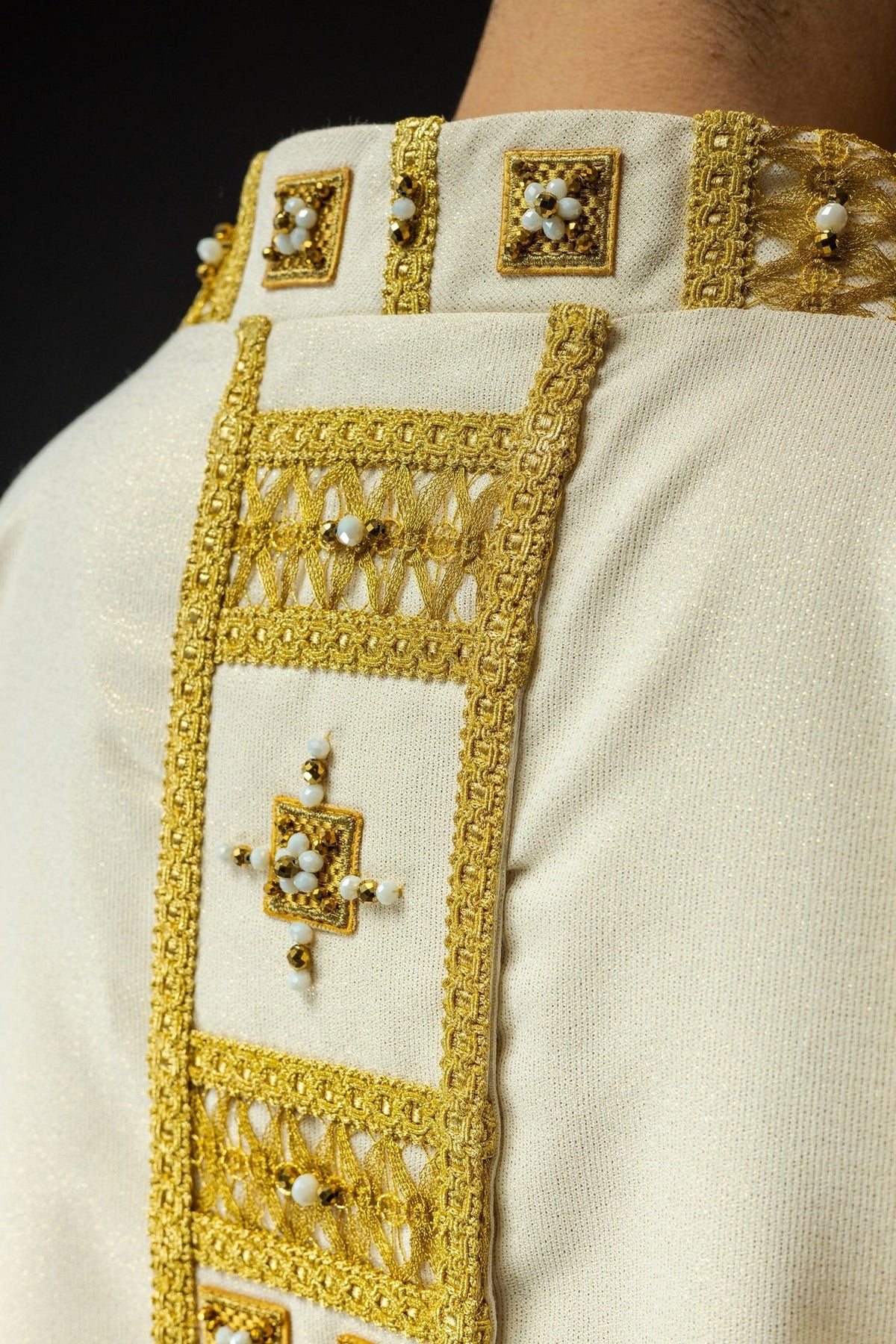 White chasuble side detail with gold orphrey, cross motif and tassel trim