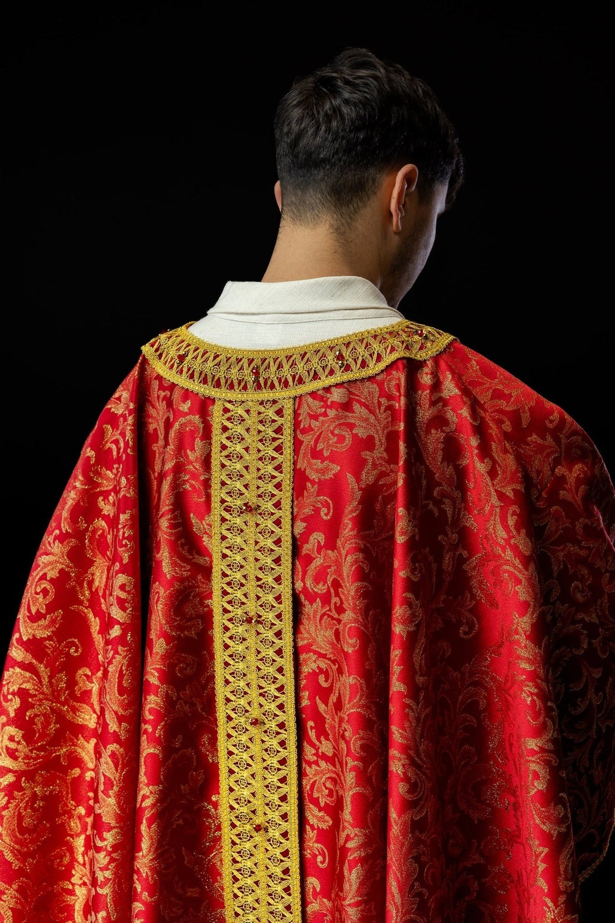Red and gold chasuble back view with ornate central orphrey