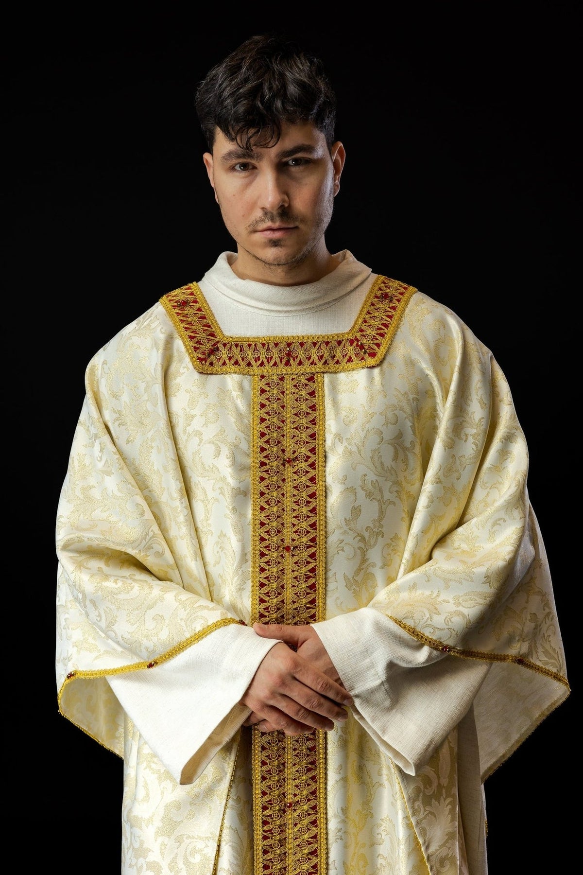 Handcrafted chasuble in white and gold with red and gold orphrey embroidery, front view worn