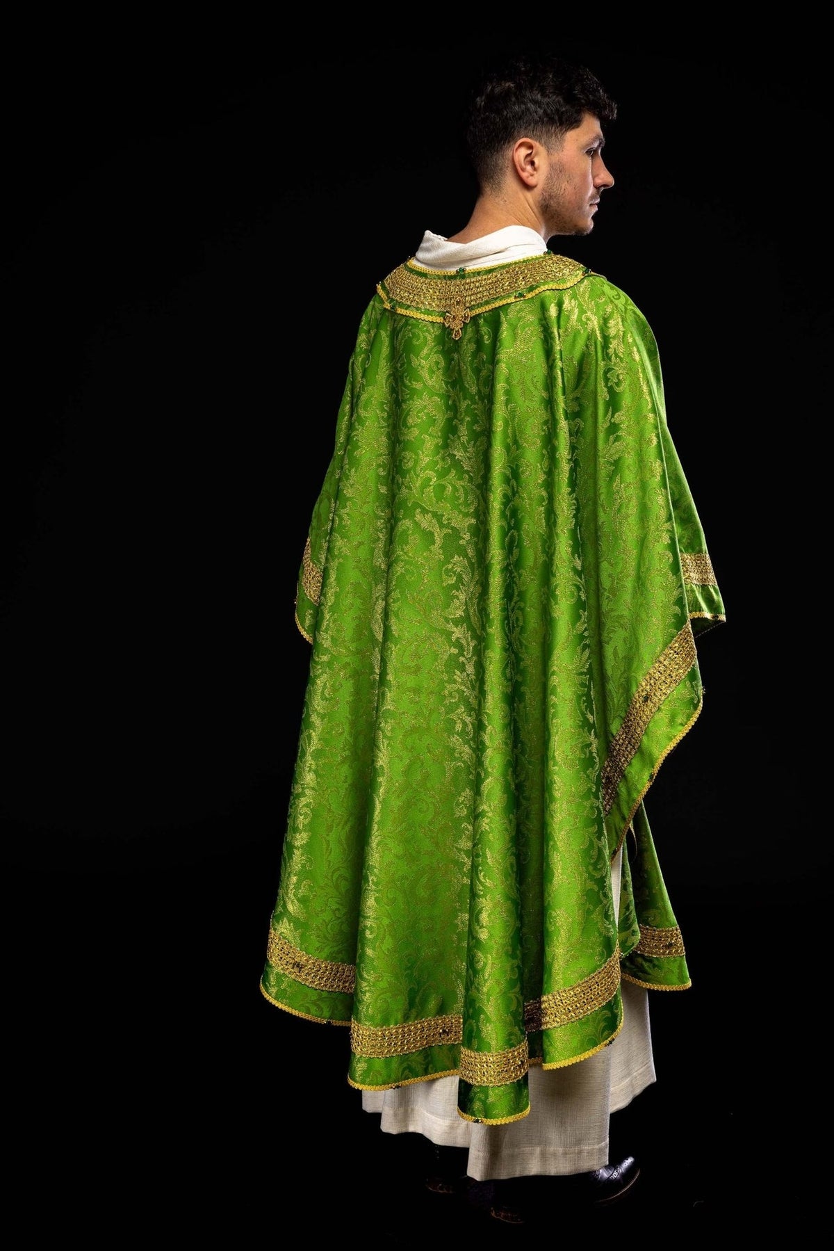 Green chasuble side view with gold trim and patterned jacquard fabric