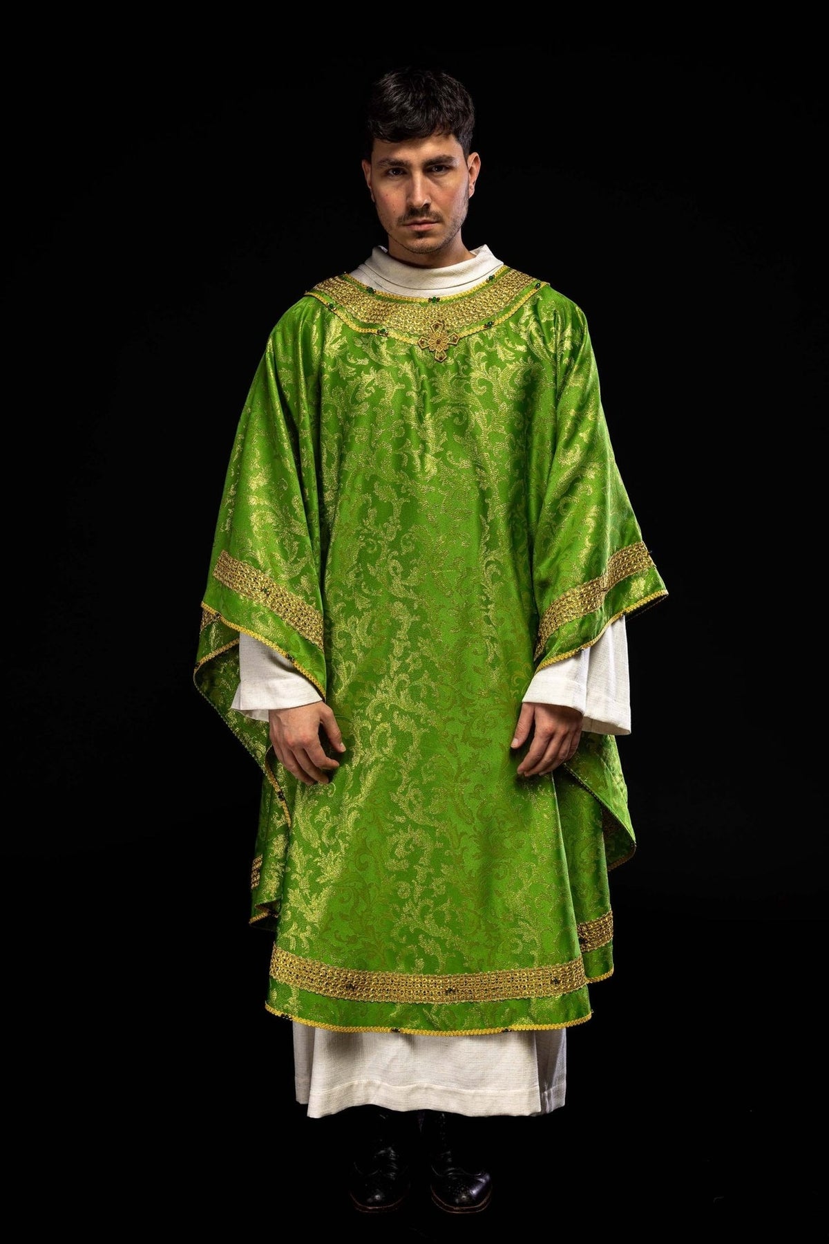 Green chasuble worn in full front view with gold trim and patterned jacquard fabric