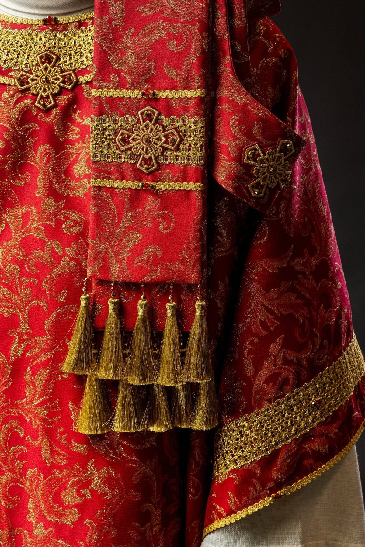 Red chasuble side detail with cross embroidery and gold tassel