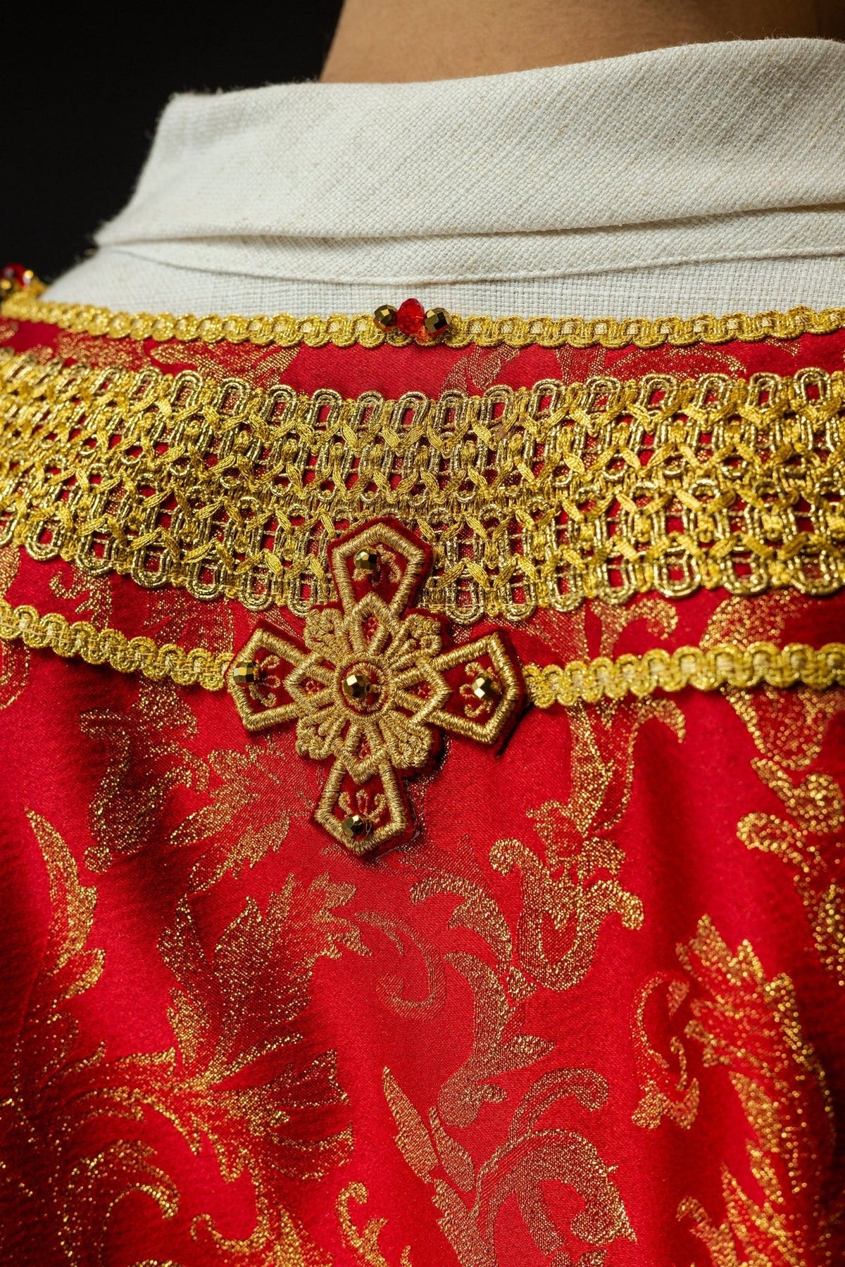 Red chasuble back view with gold trim and floral jacquard fabric