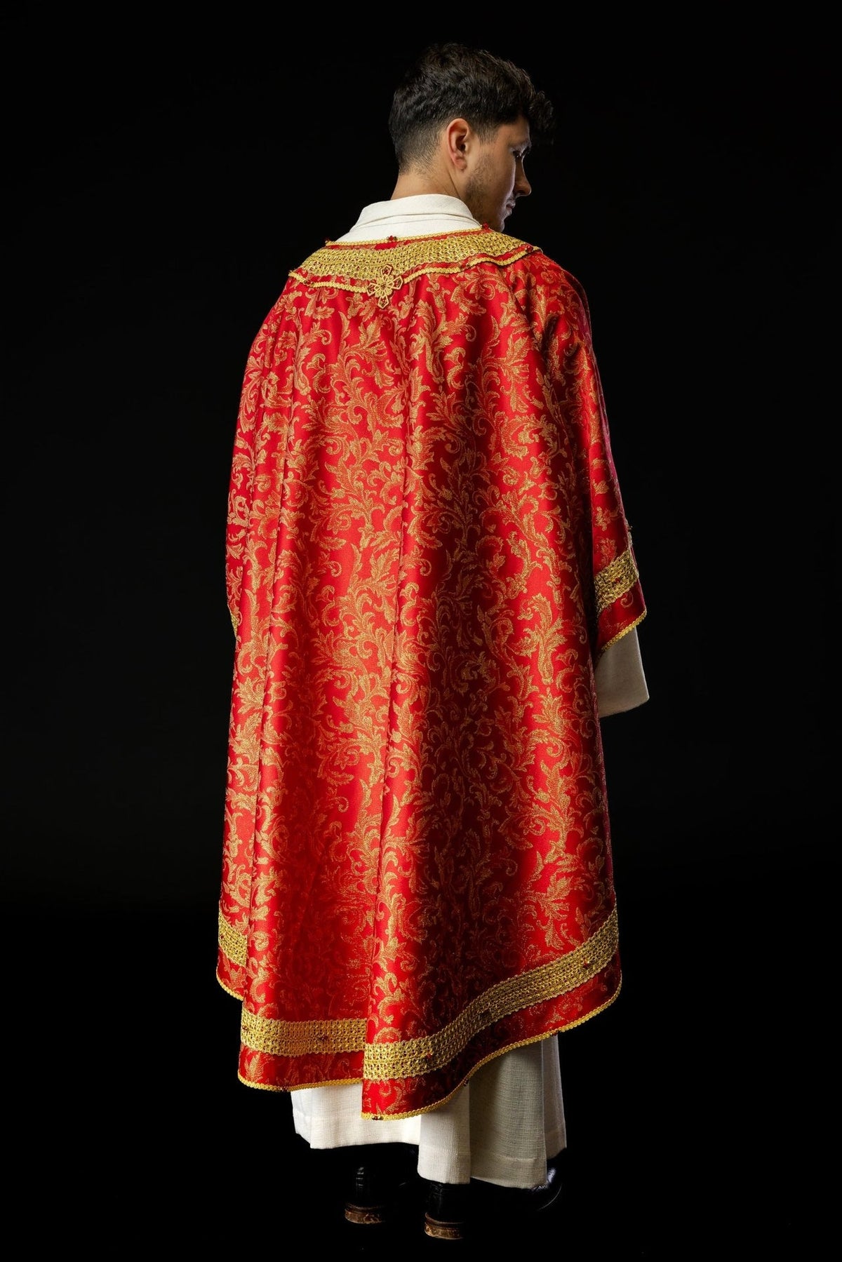 Red chasuble three-quarter back view with gold trim and floral fabric