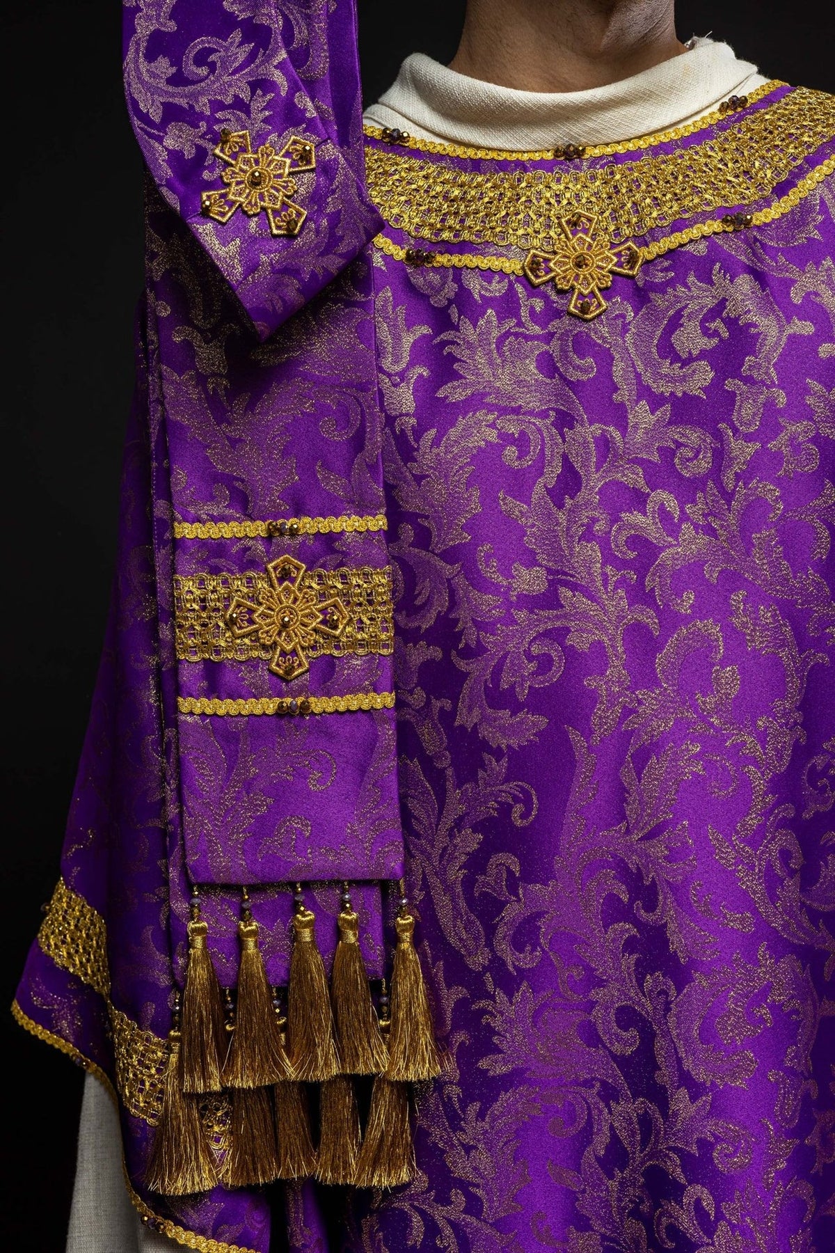 Purple chasuble front detail with gold cross embroidery and natural stones