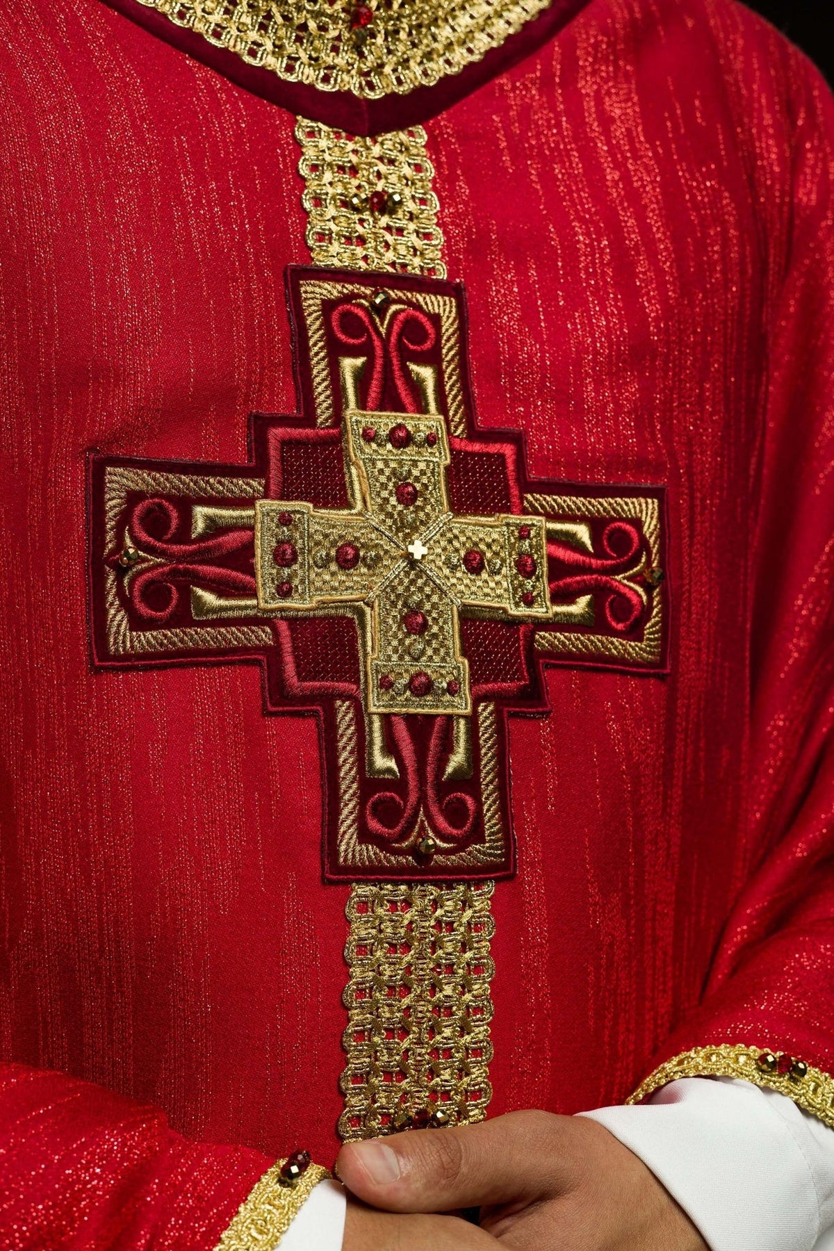 Red chasuble close-up of gold cross embroidery with natural stones