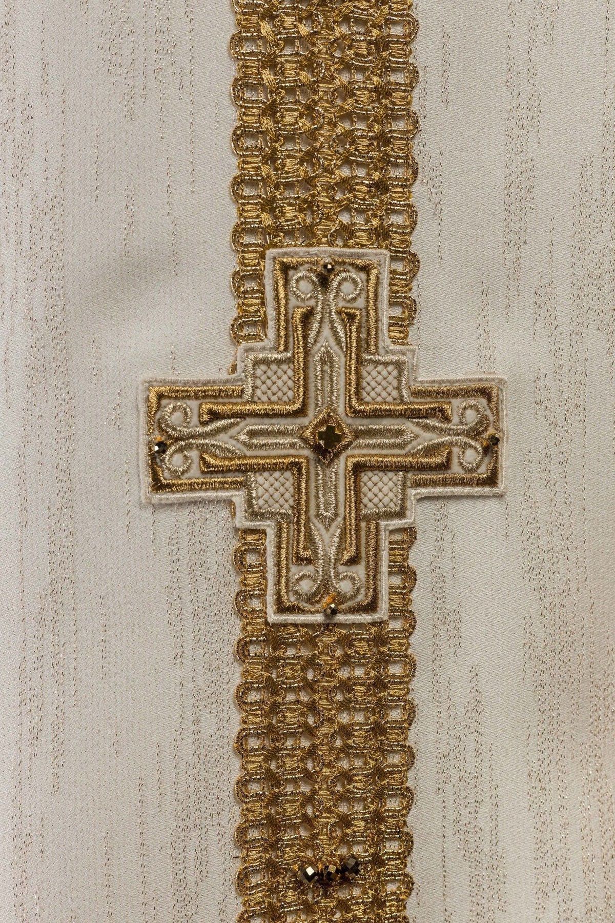 Ecru chasuble back detail with gold cross embroidery and natural stones