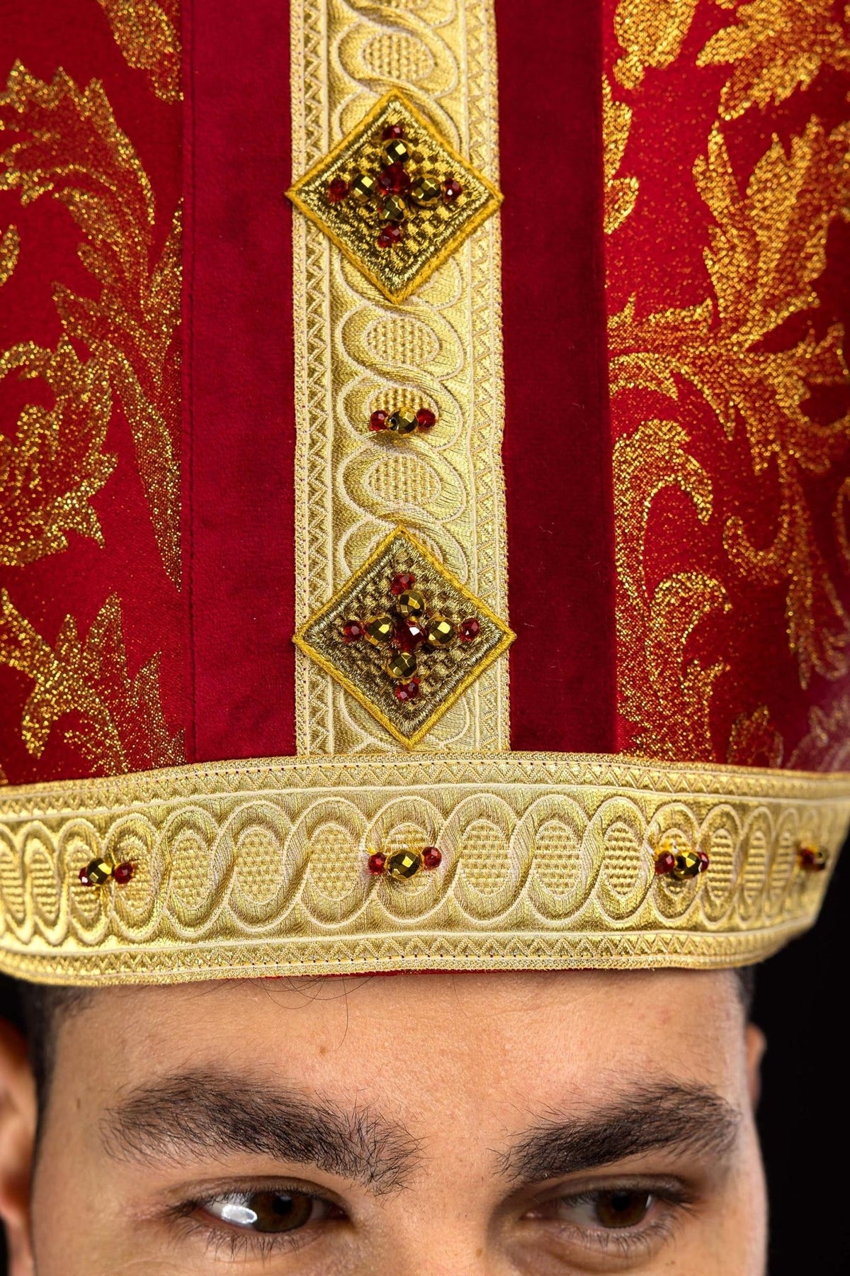 Red miter with gold embroidery, back view showing matching hanging panels and tassels