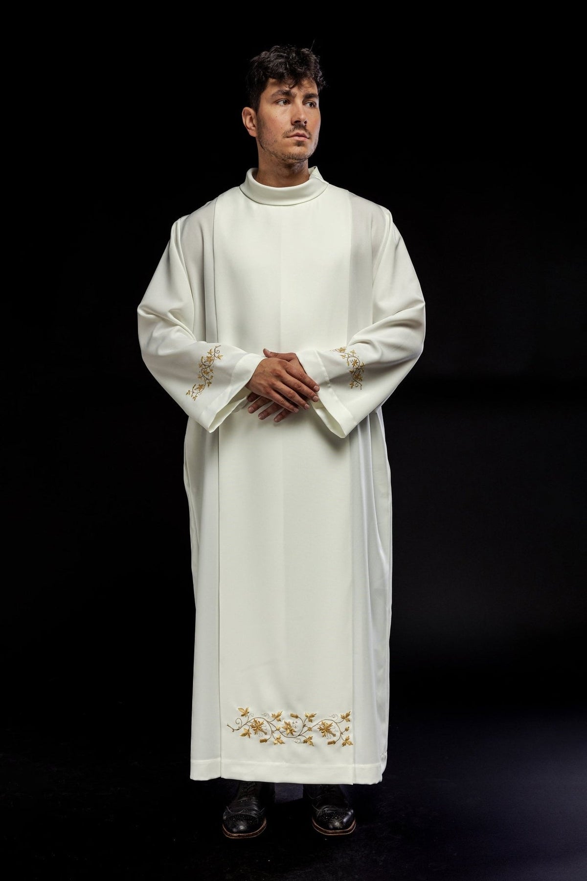 Ecru alb worn from the front with gold embroidery at the cuffs and hem