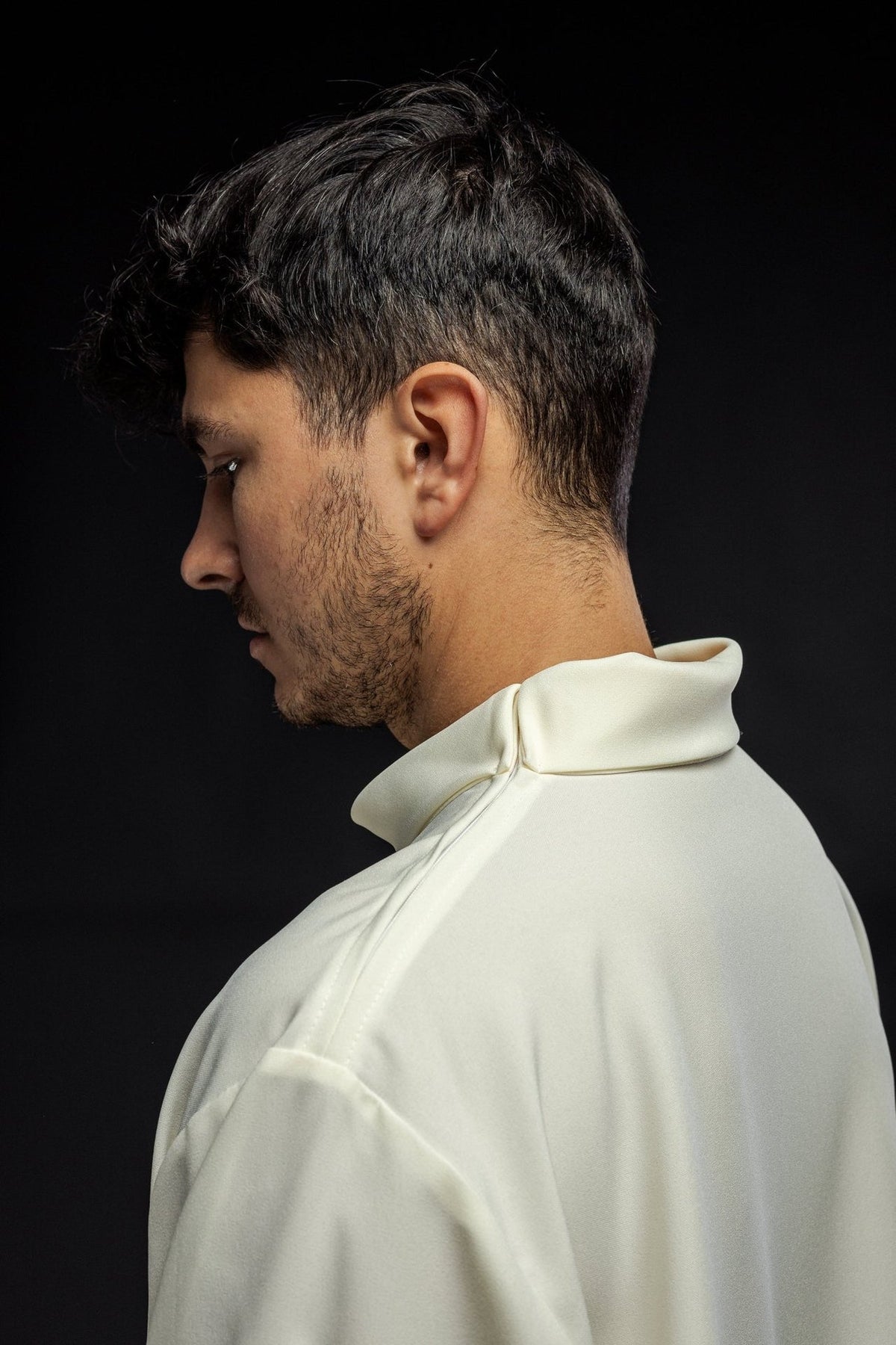 Ecru alb side close-up, showing the folded high collar and shoulder seam