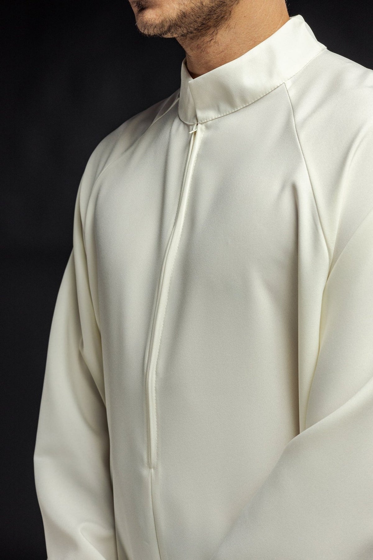 Ecru priest alb close-up showing the front zipper and collar