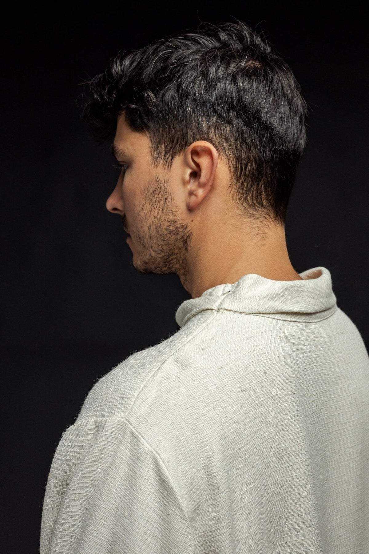 Linen priest alb in ecru, close-up side view of rolled collar and shoulder seam