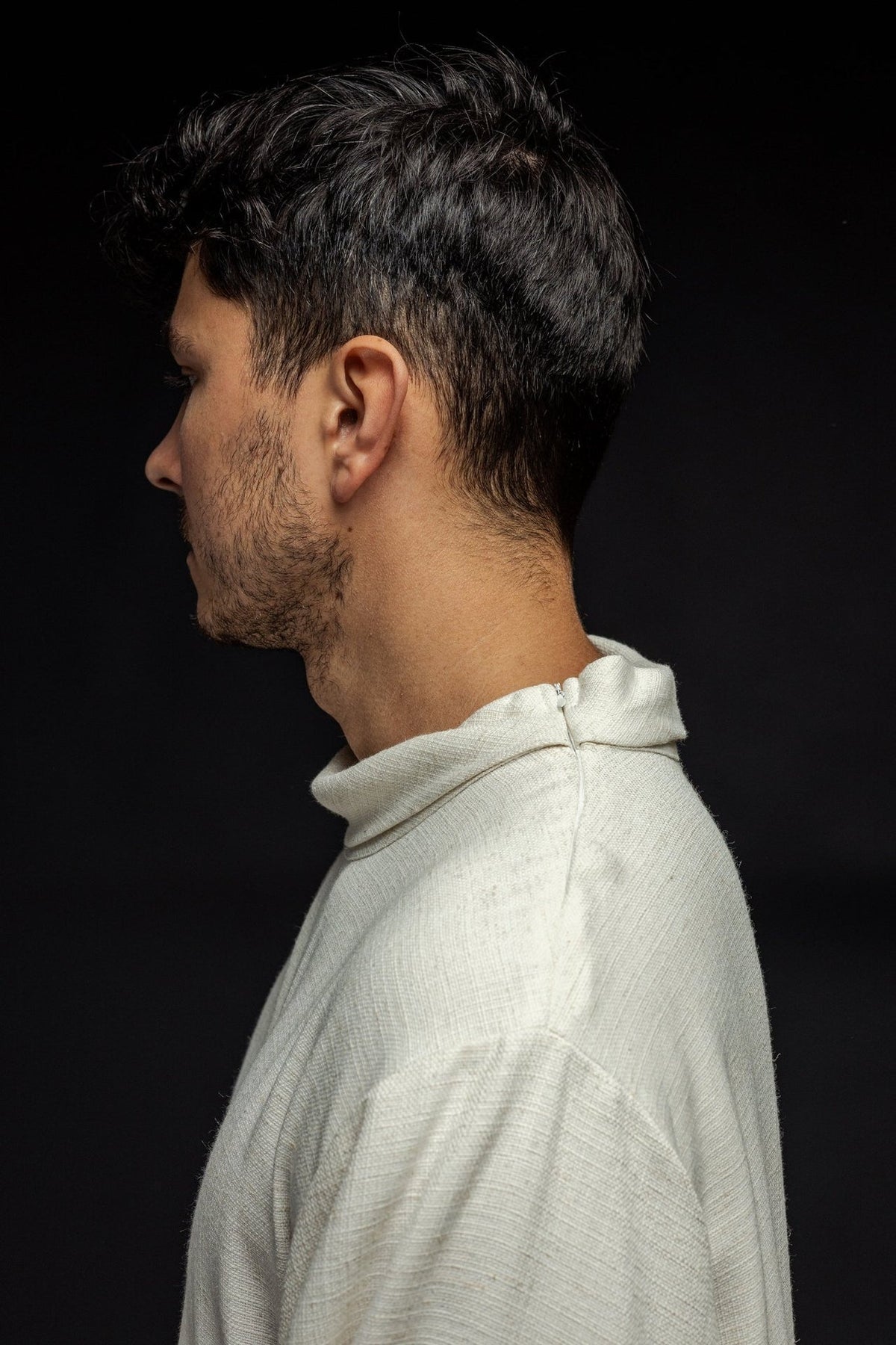Linen priest alb in ecru, side close-up showing collar fastening and natural-weave fabric