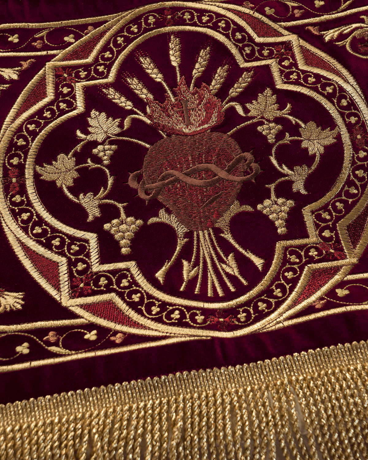 Church canopy close-up showing Sacred Heart of Jesus embroidery and gold fringe