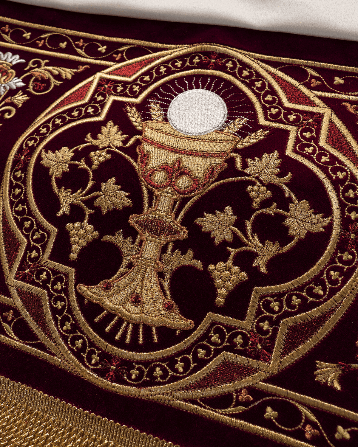 Church canopy close-up showing communion chalice embroidery with wheat and vine