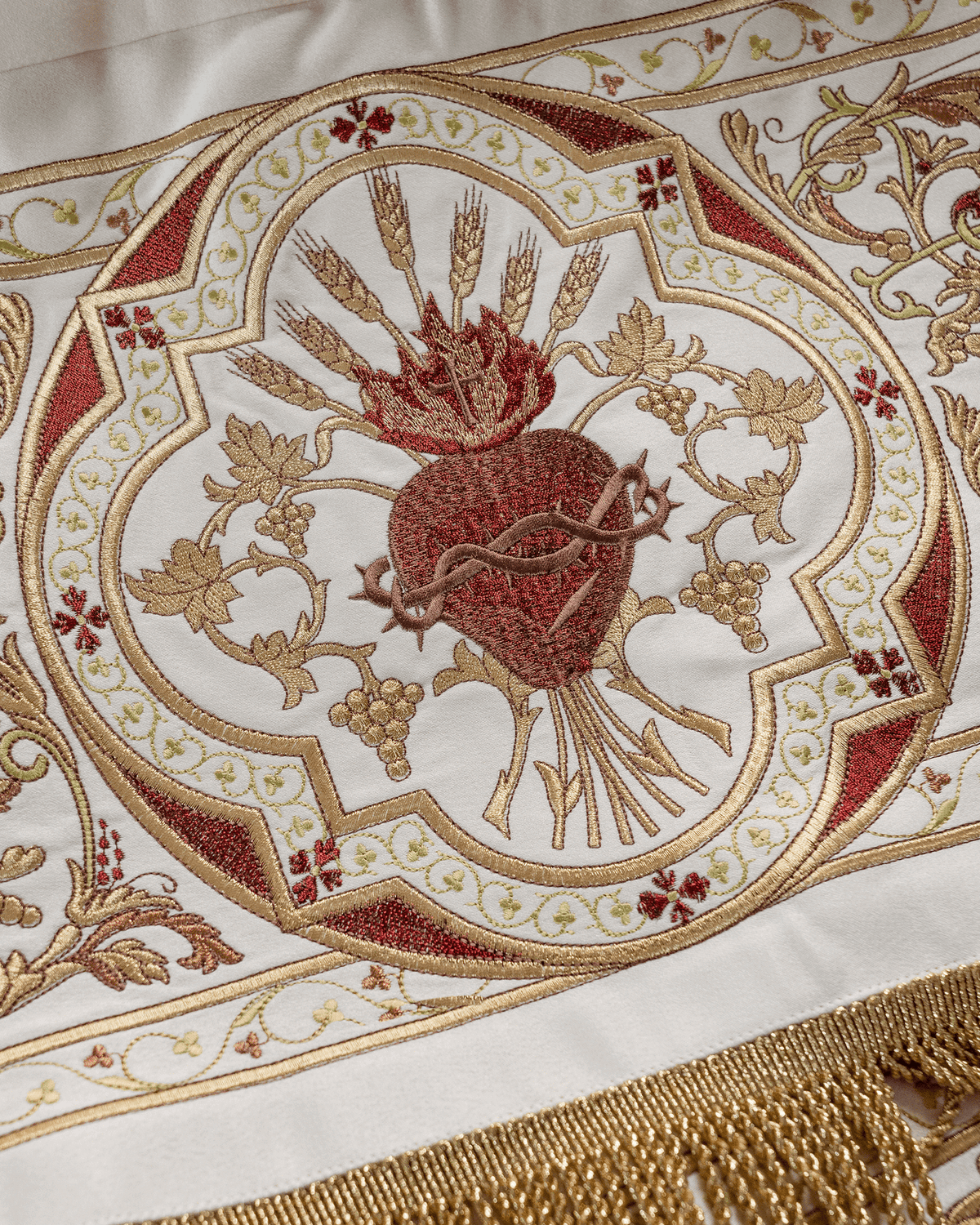 Processional canopy close-up with embroidered Sacred Heart of Jesus, wheat and vine motifs