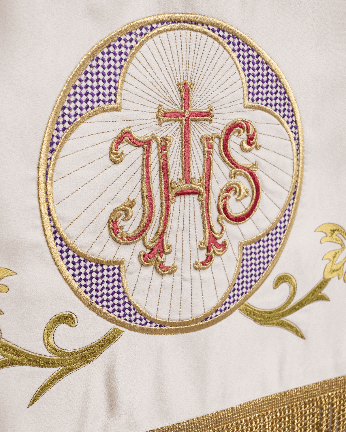 Liturgical canopy close-up with embroidered JHS medallion, purple border and gold scrollwork