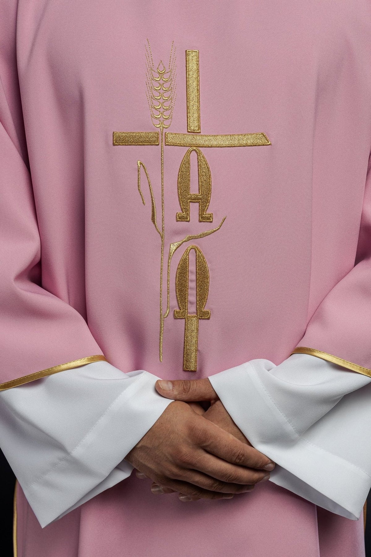 Rose dalmatic close-up showing gold Alpha and Omega embroidery and wheat motif