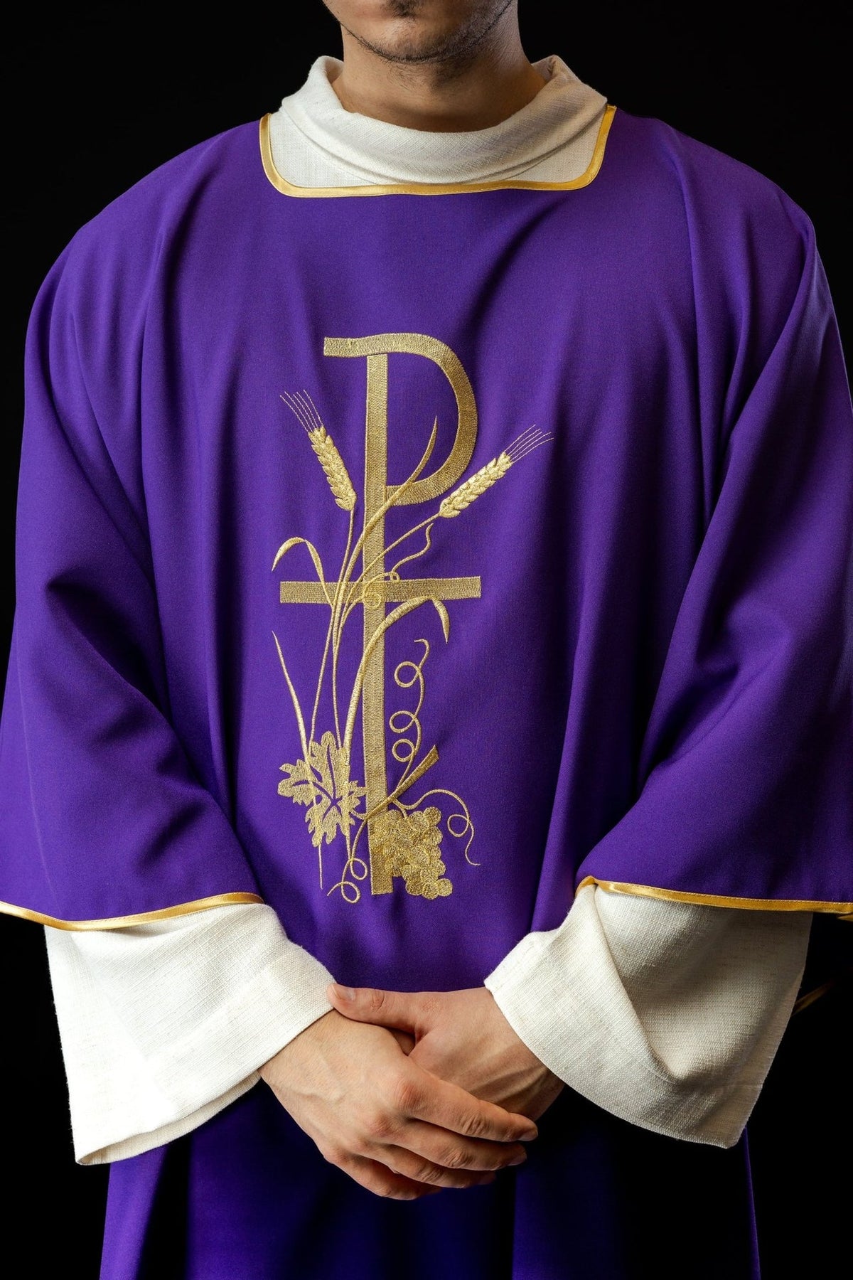 Purple dalmatic front close-up showing gold PAX cross embroidery and gold trim