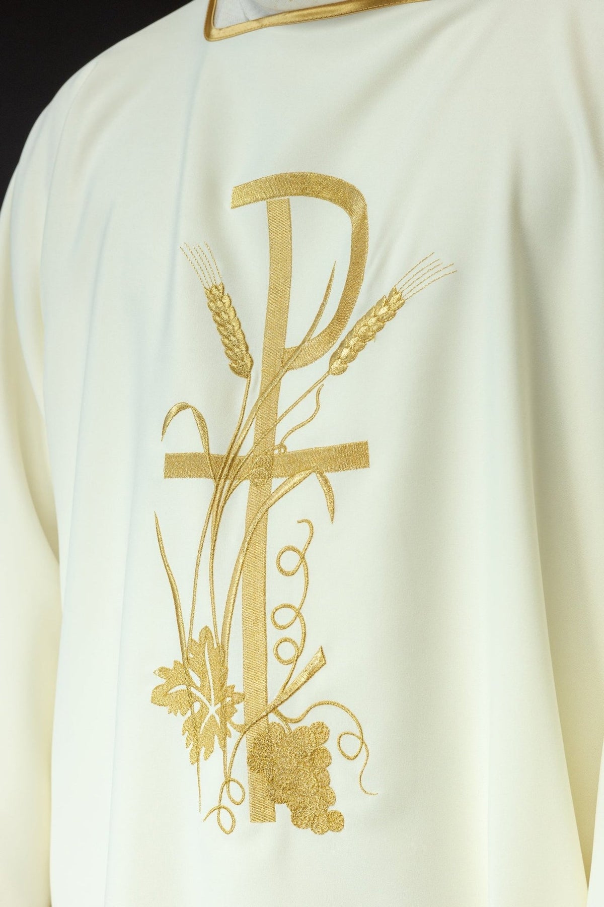 Ecru dalmatic embroidery close-up with gold PAX cross, wheat, vines and grapes