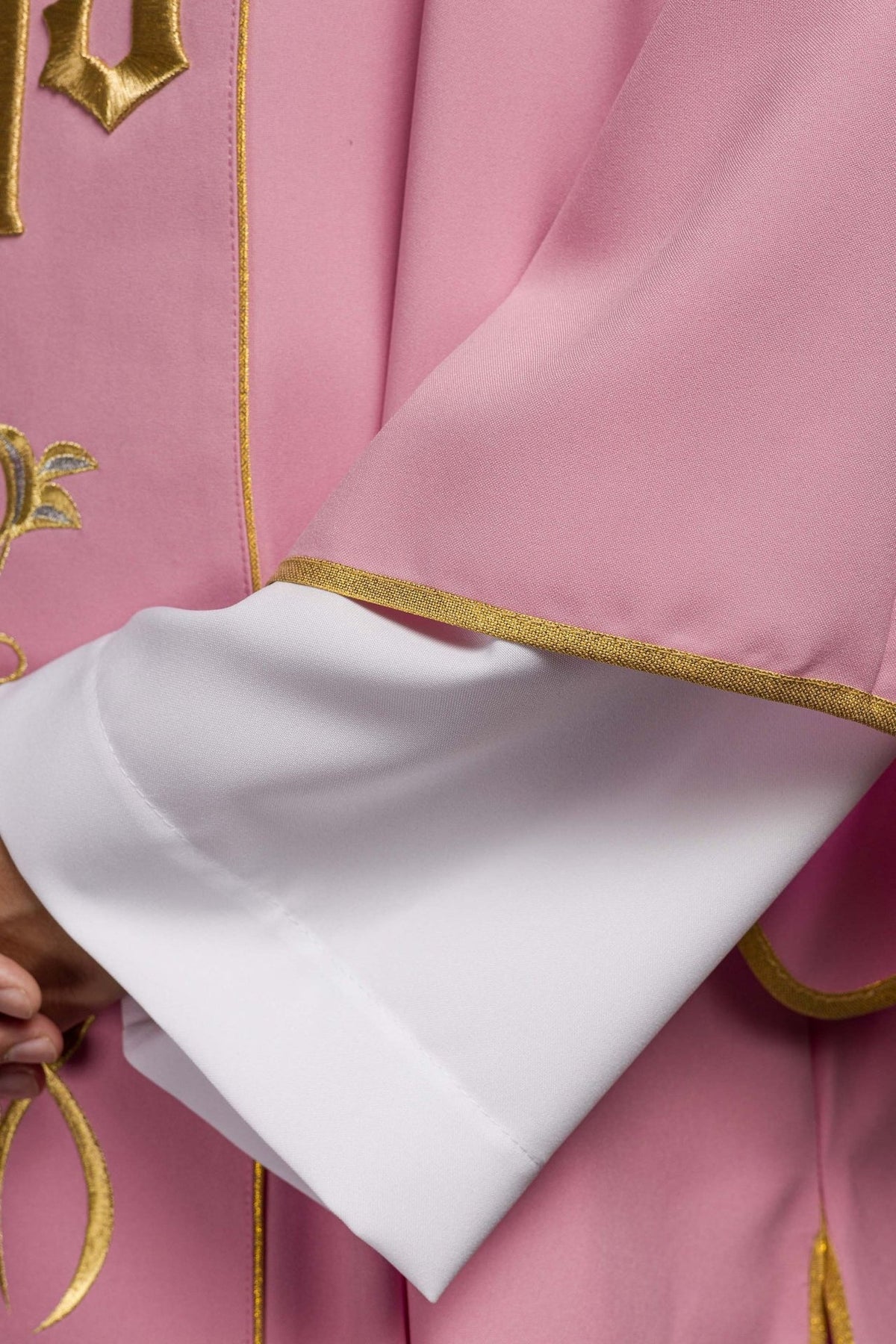 Rose dalmatic sleeve close-up with gold trim and white cuff