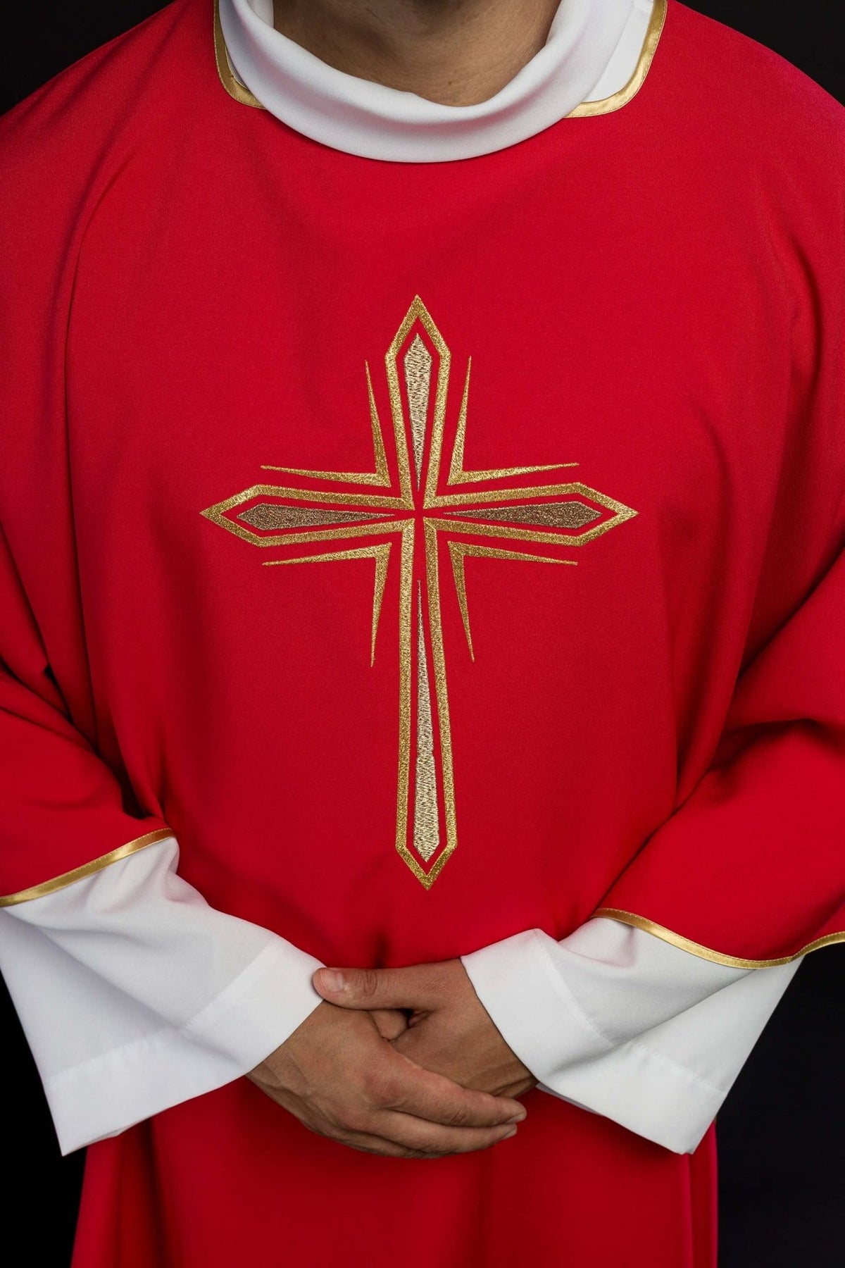 Red dalmatic close-up showing embroidered gold cross and gold trim
