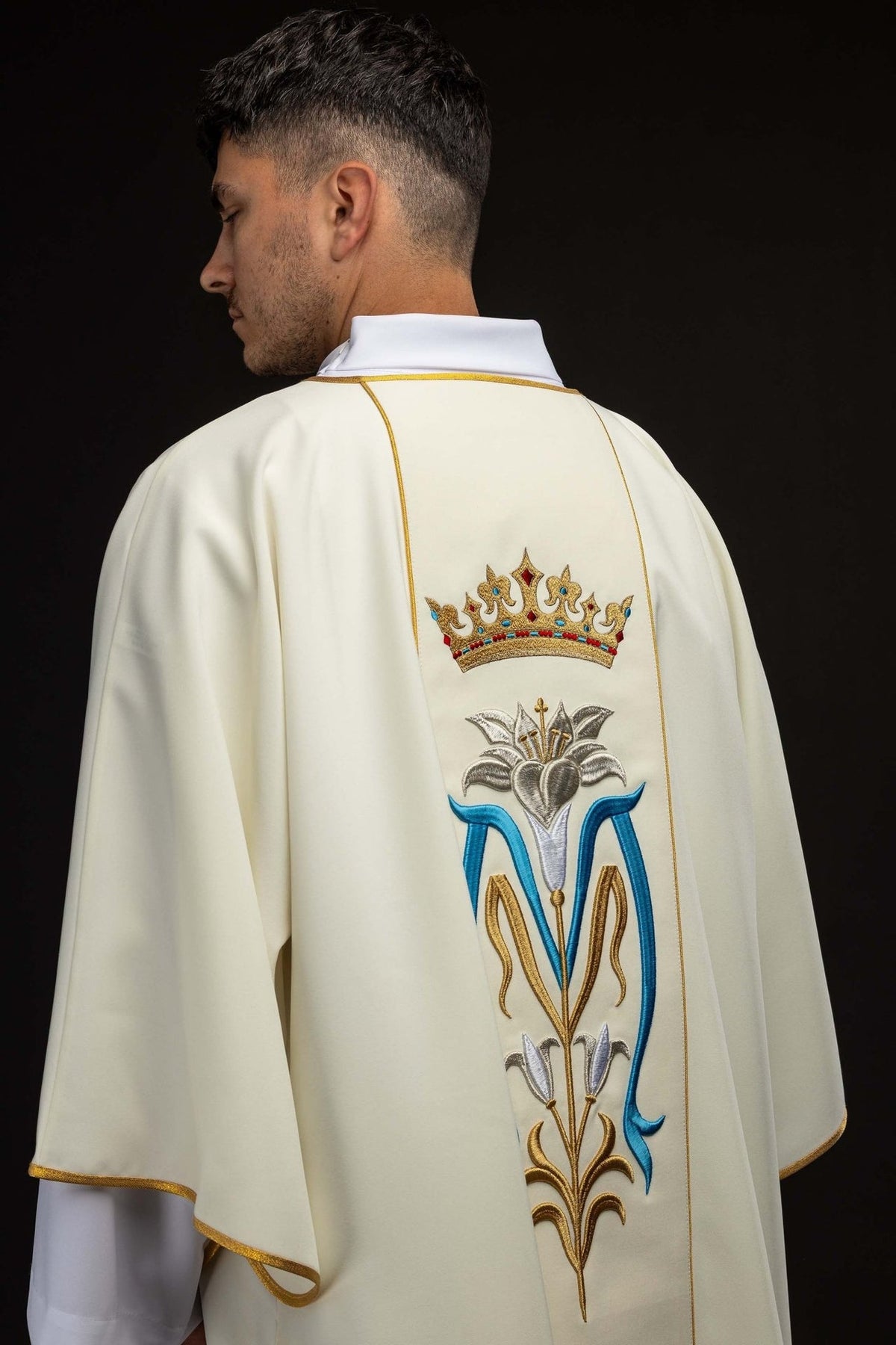 Ecru dalmatic back view with embroidered Marian symbol and gold trim
