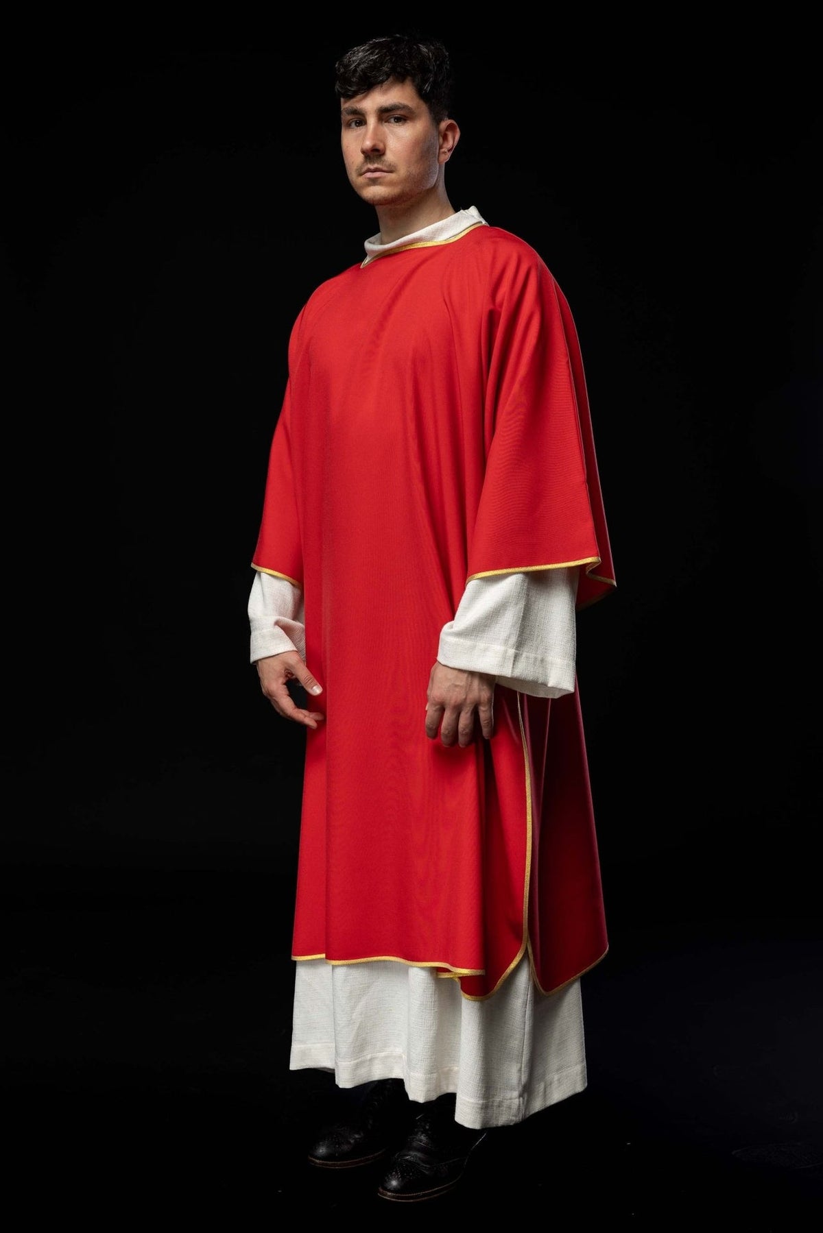 Red dalmatic with gold trim, side view showing flowing shape and edged sleeves