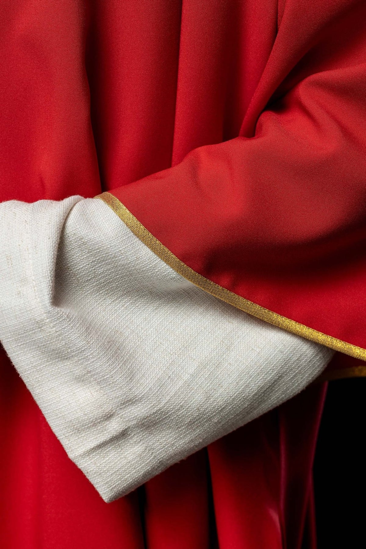 Red dalmatic fabric and gold trim close-up