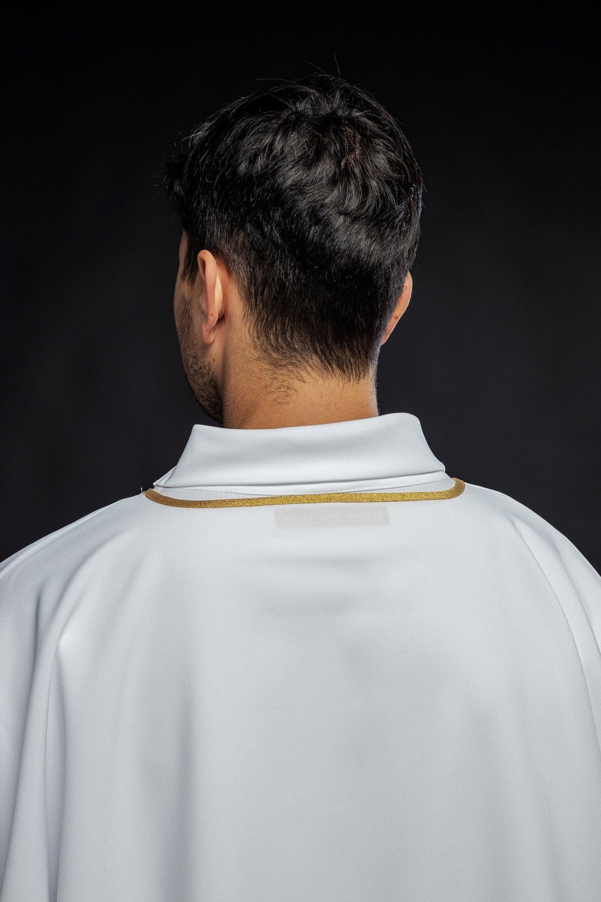 White dalmatic with gold trim, close back view of the collar and smooth fabric