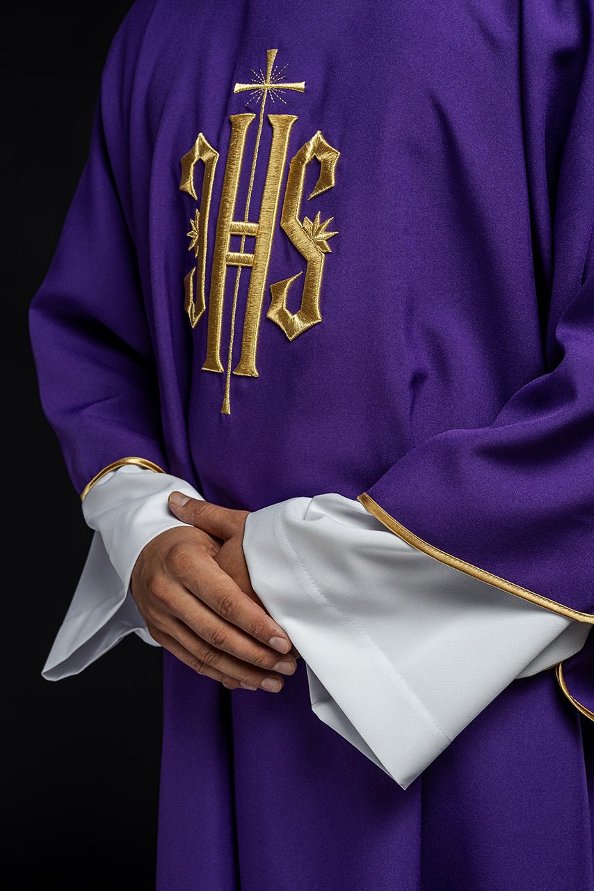 Purple dalmatic close-up showing embroidered gold IHS and gold-trimmed white cuffs