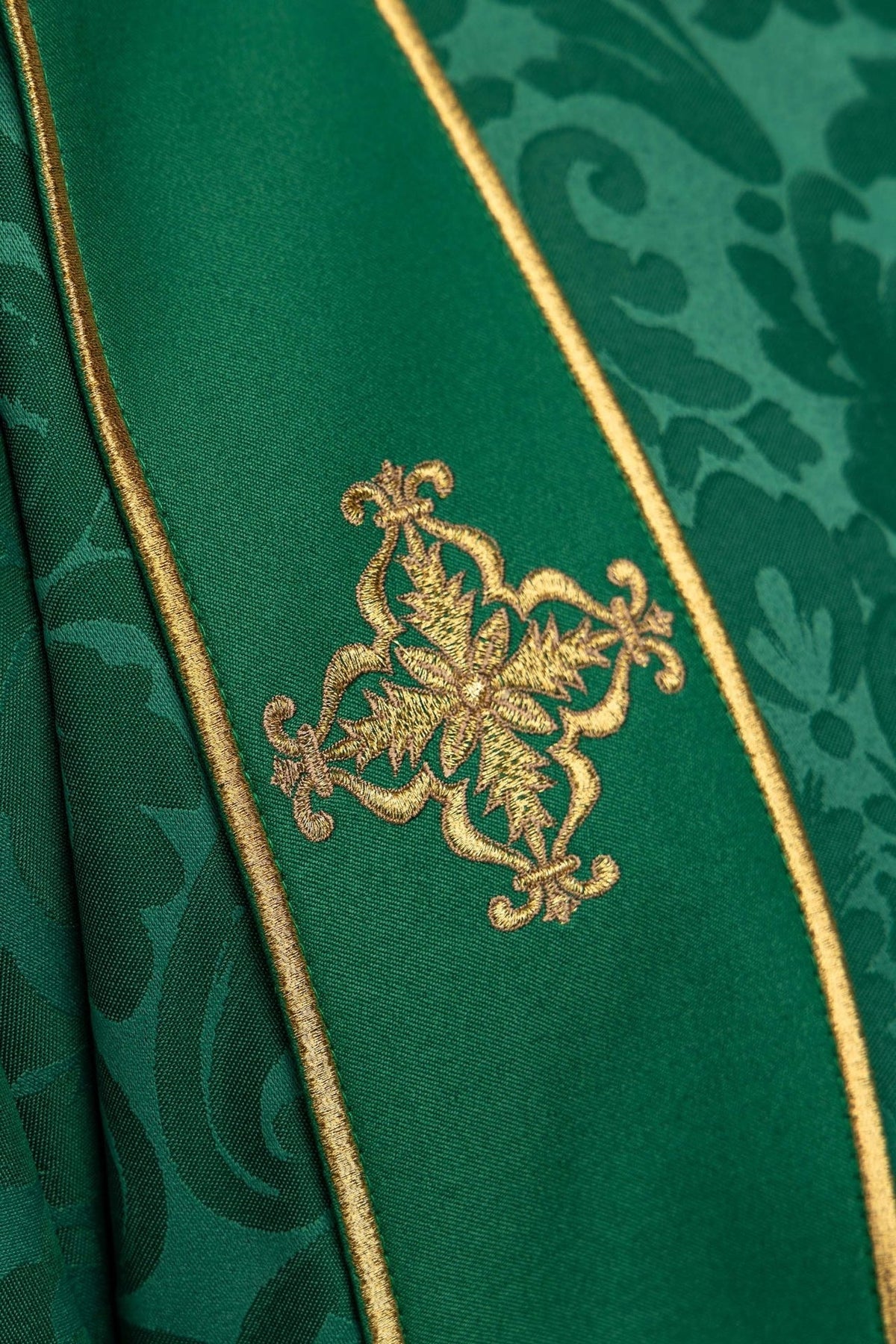 Green dalmatic detail showing gold embroidered cross and trim