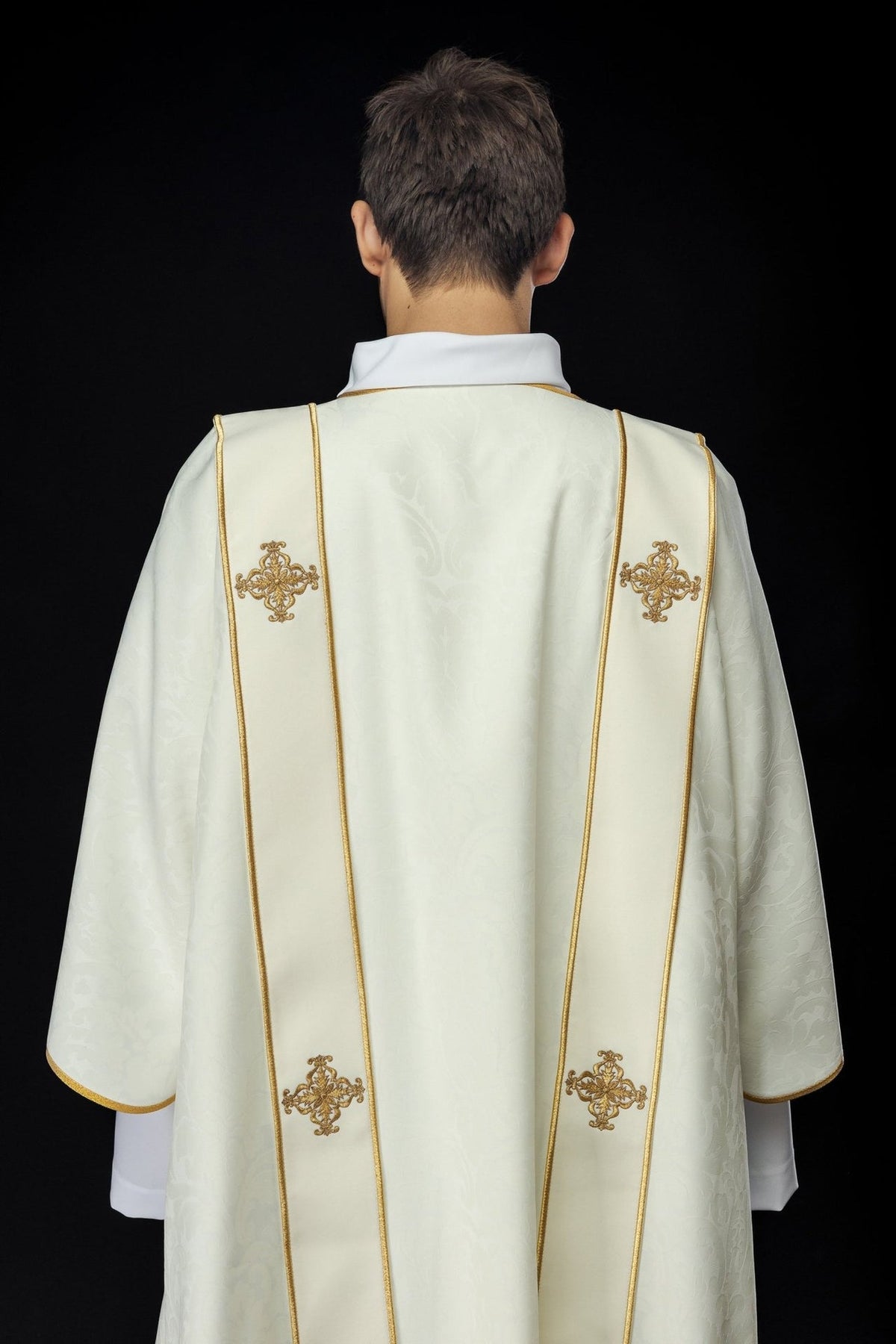 Ecru dalmatic back view with gold-trimmed orphreys and embroidered crosses