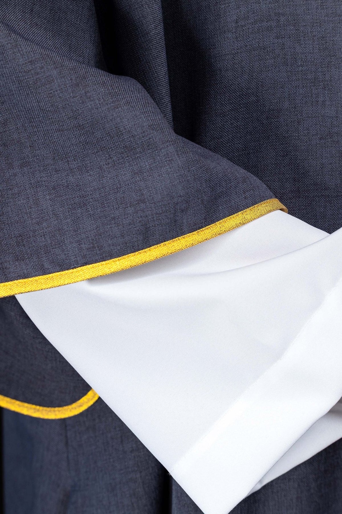 Purple dalmatic close-up showing gold trim and white sleeve