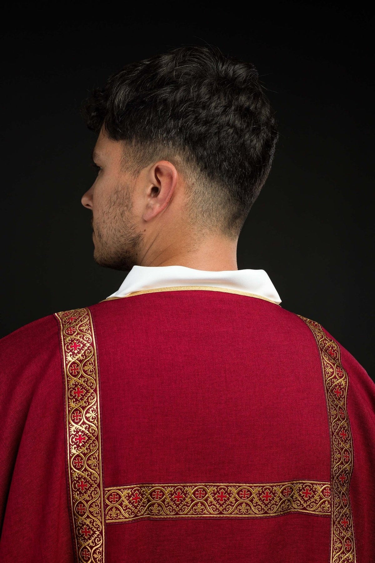 Red dalmatic sleeve detail with gold trim and white cuff