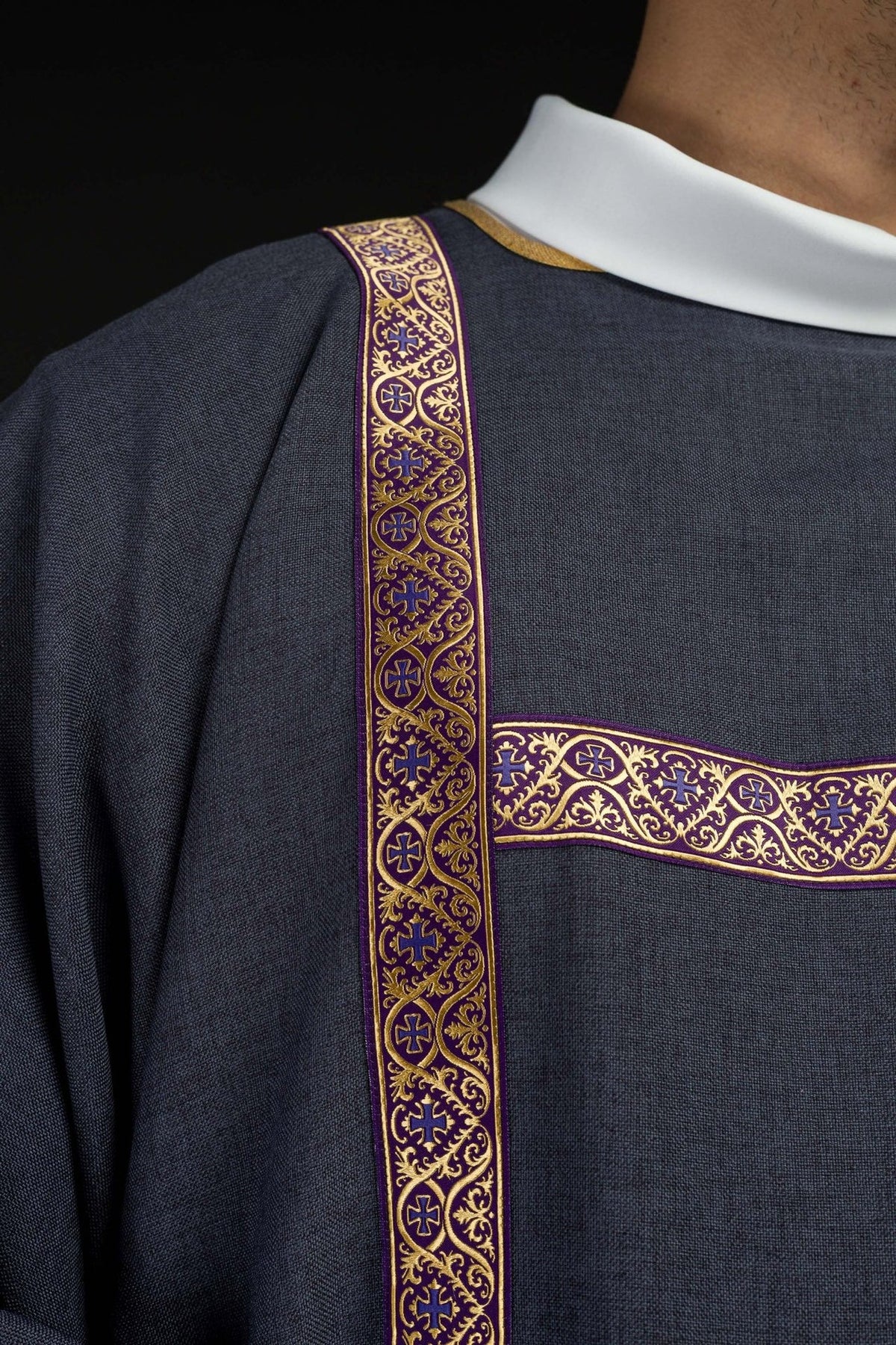 Purple dalmatic close-up of gold jacquard orphrey with cross and vine motifs