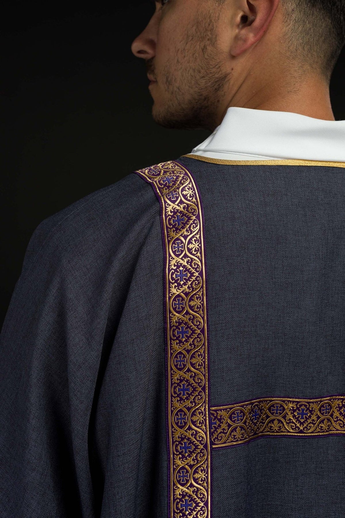 Purple dalmatic back view with gold jacquard orphreys and horizontal bands