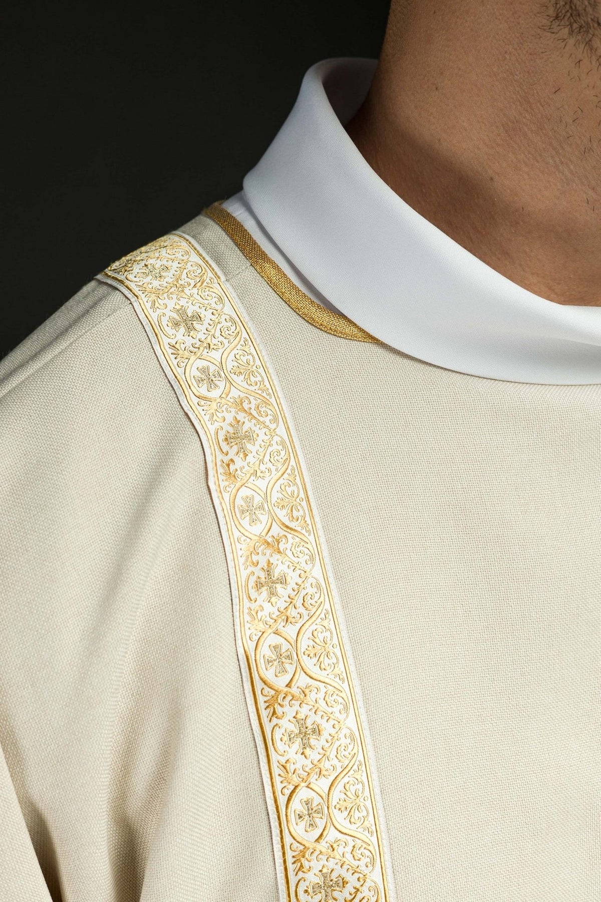 Ecru dalmatic close-up showing gold jacquard orphrey with cross motifs