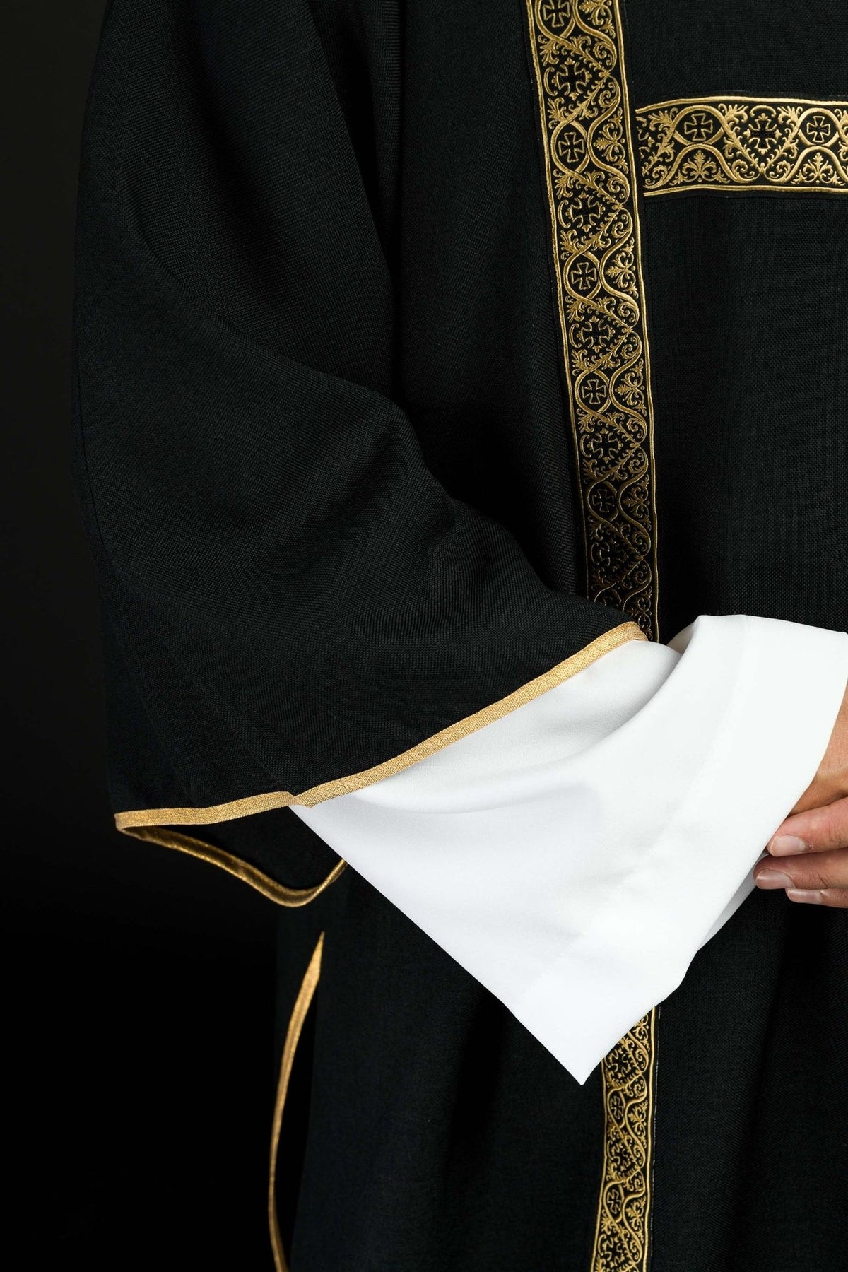 Black dalmatic sleeve close-up with gold trim and white lining