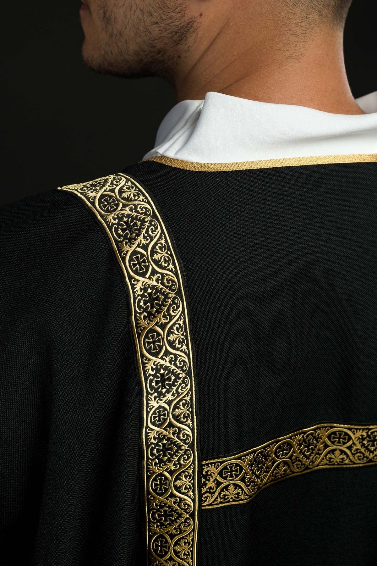 Black dalmatic shoulder close-up with gold jacquard orphrey