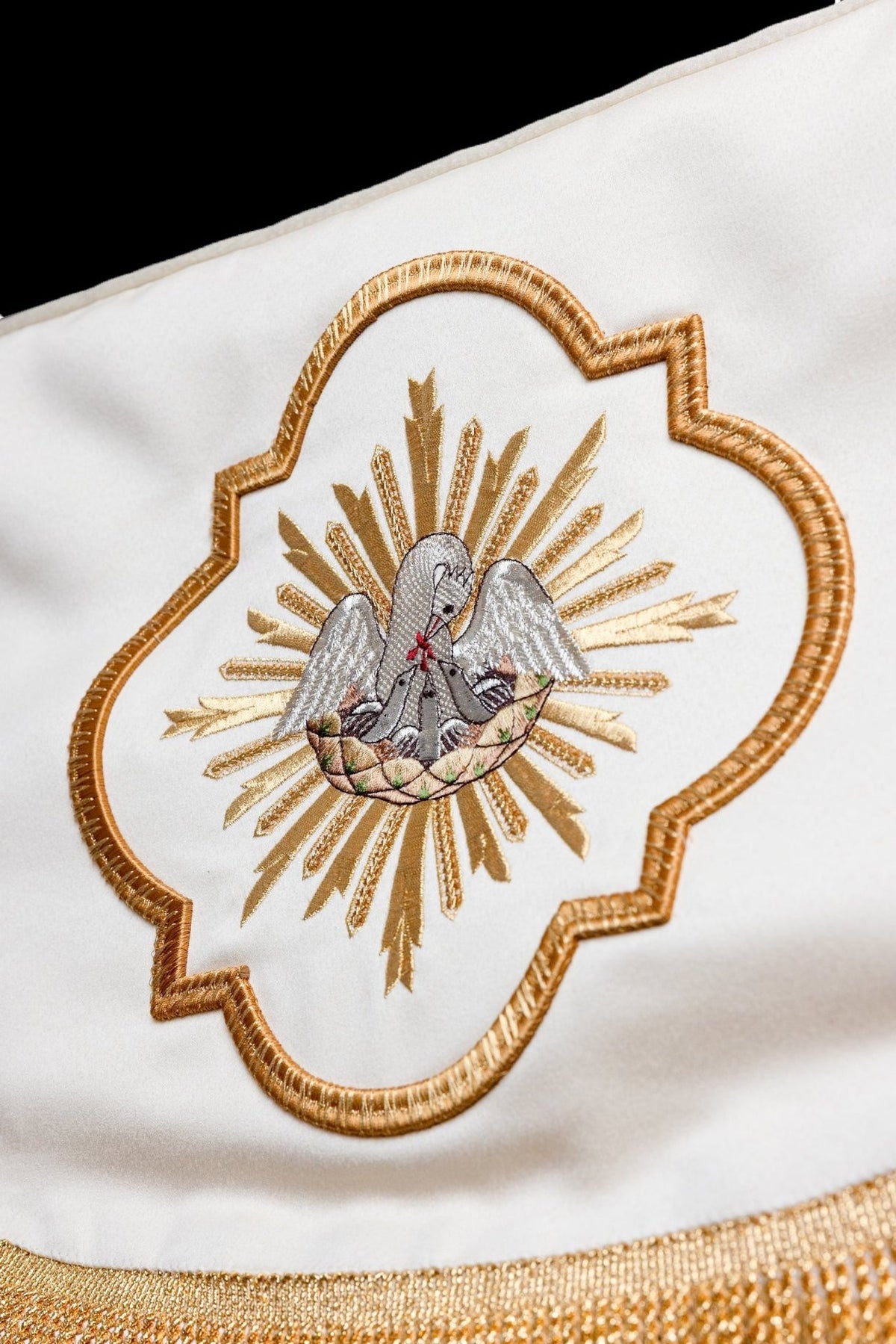 Canopy close-up with embroidered pelican medallion and gold fringe