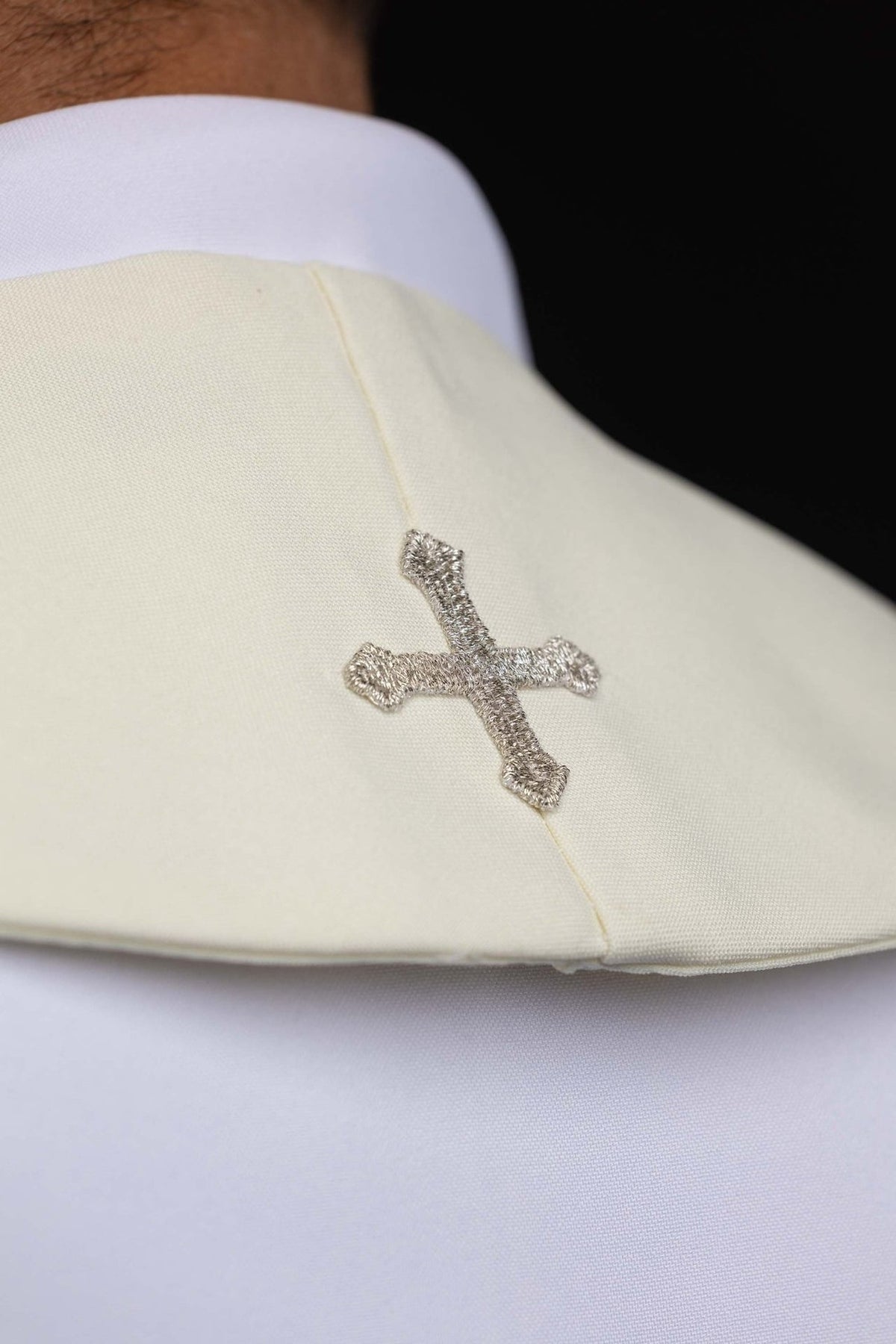 Ecru embroidered stole, close-up of silver cross at the center seam