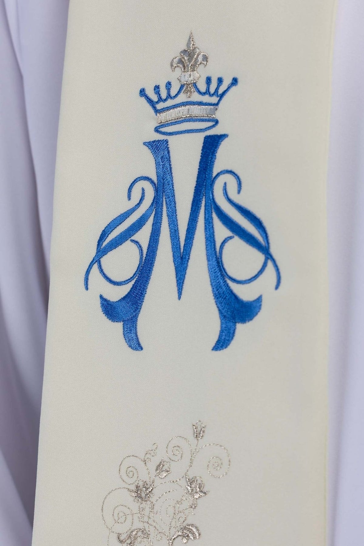 Marian stole close-up showing blue crowned Marian symbol and silver embroidery on ecru fabric