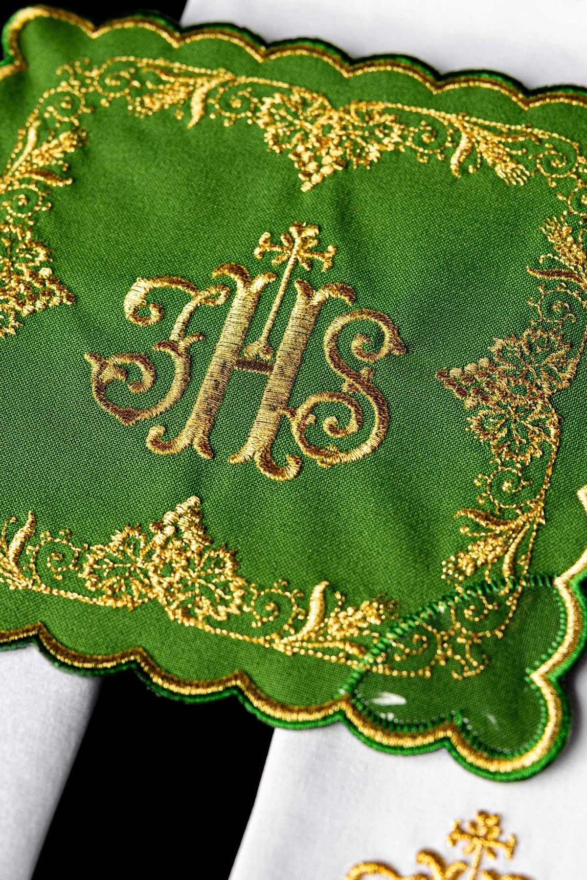 Altar linen set close-up showing green fabric, gold IHS monogram and ornate embroidery