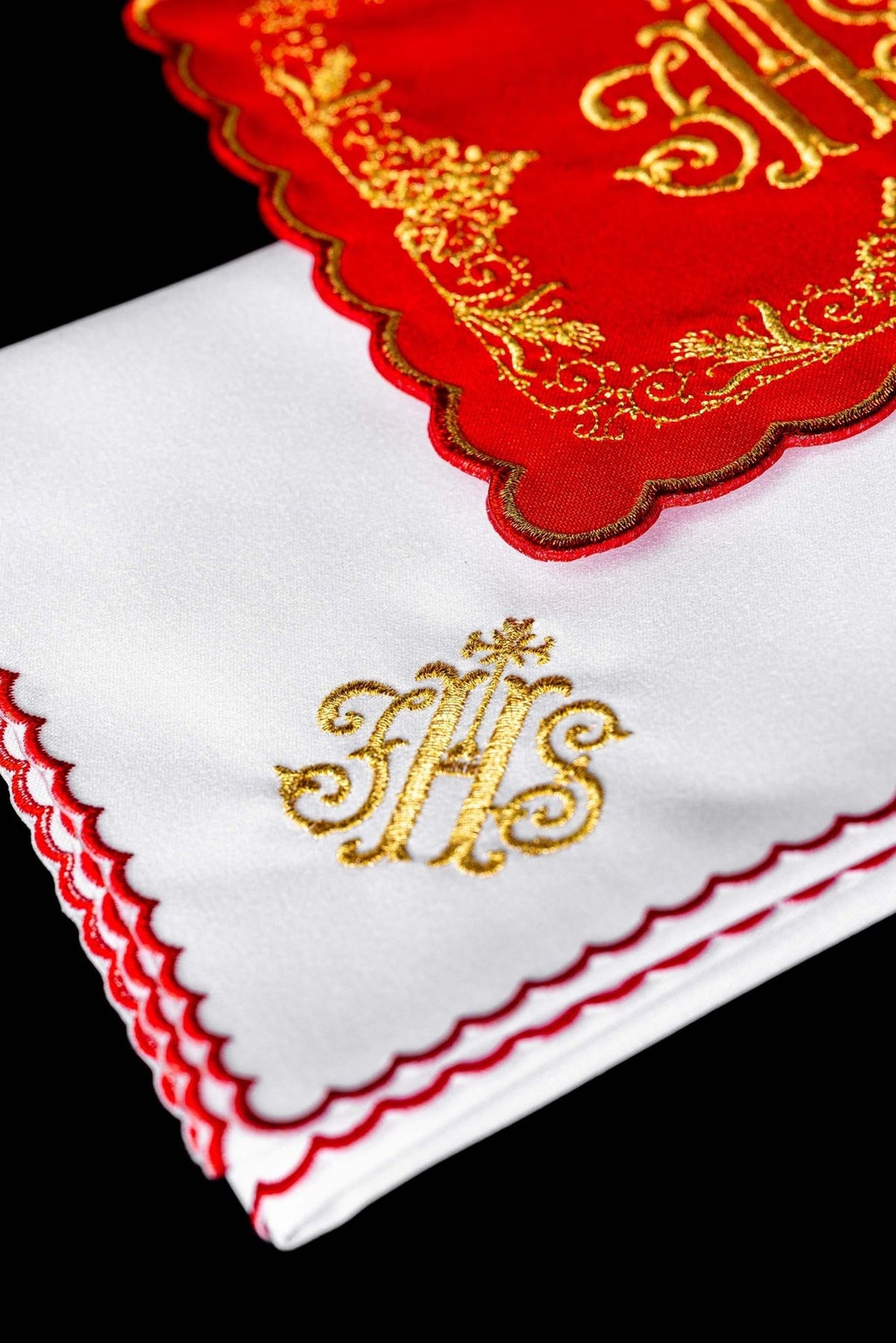 Altar linen close-up showing gold embroidered IHS and red scalloped trim