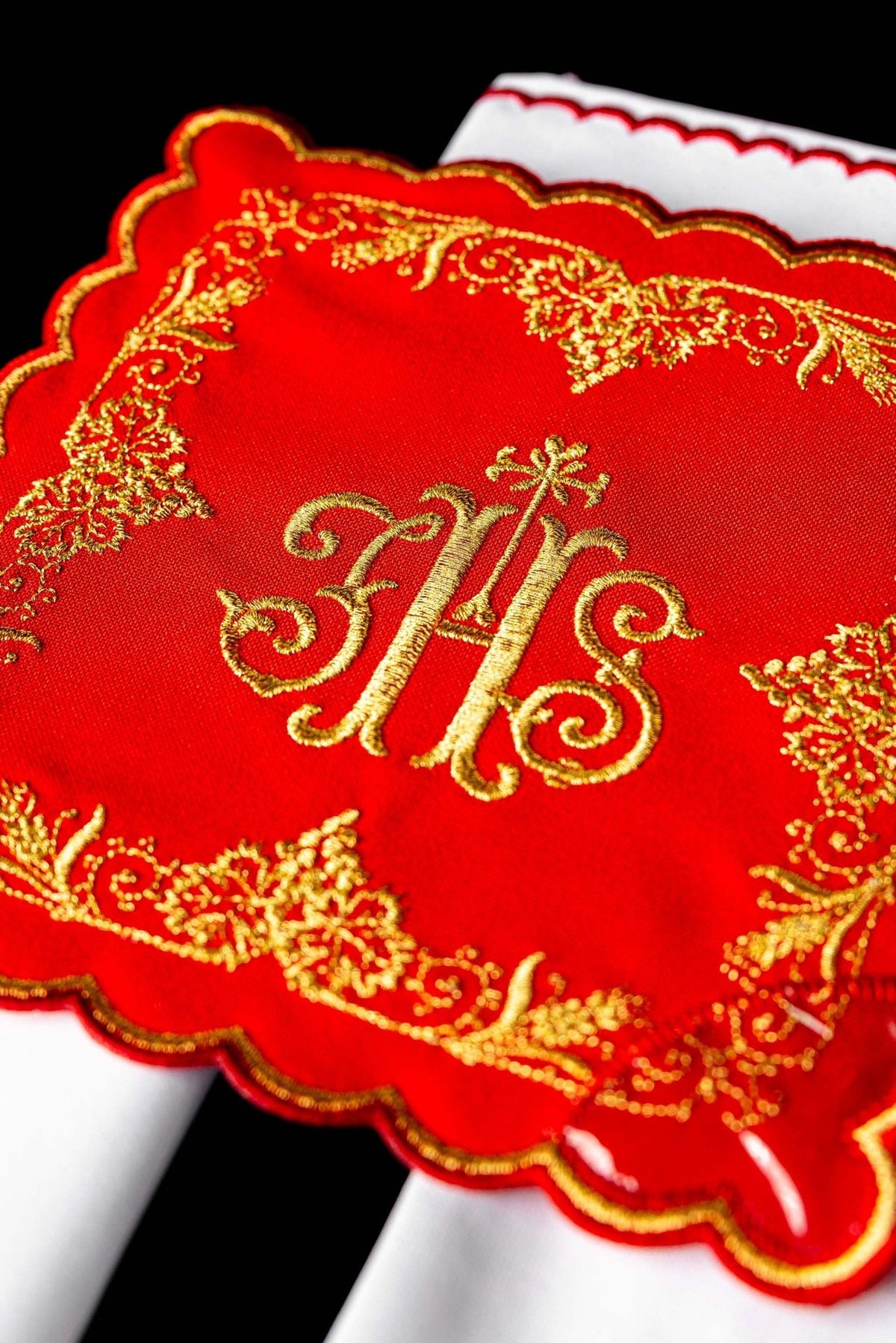 Red chalice pall detail with ornate gold embroidery and scalloped edge