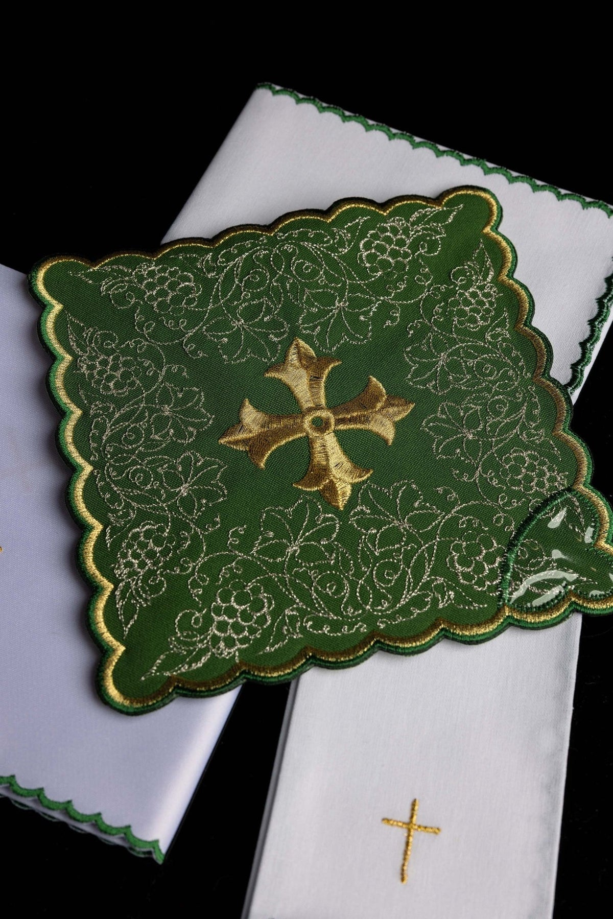 Altar linen set close-up with green floral panel, gold cross and white linens