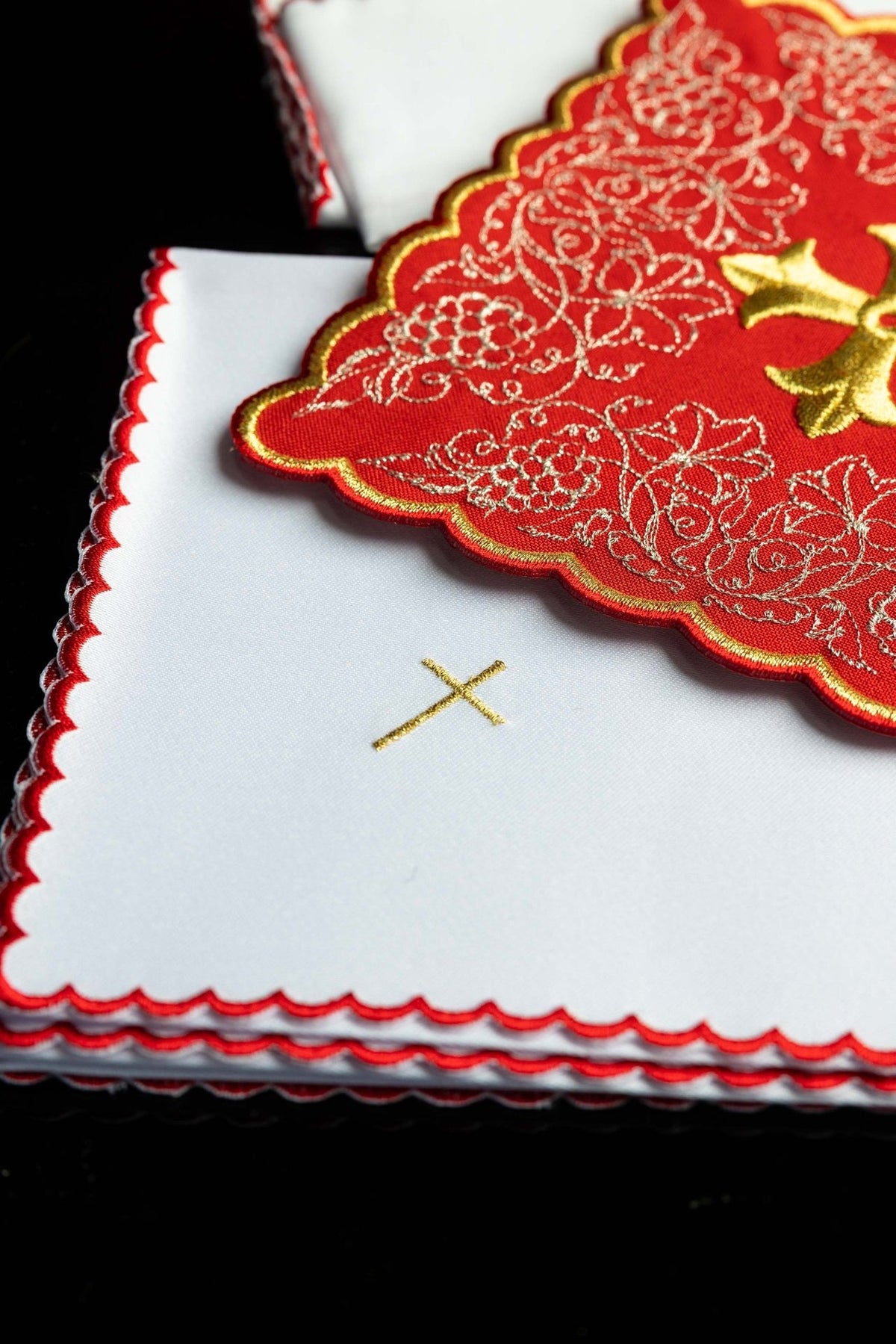 Altar linen set detail showing gold cross and scalloped red edging